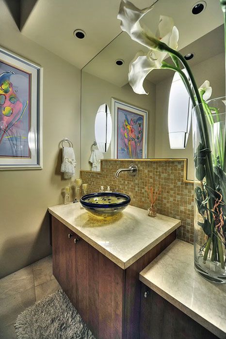 A bathroom with a sink and a vase of flowers on the counter.