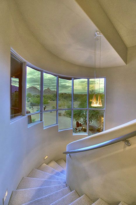 A spiral staircase in a house with a lot of windows.