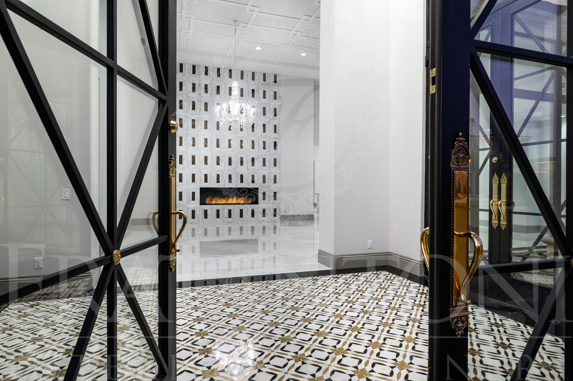 Modern interior foyer with black metal doors framing a white patterned custom fireplace and mosaic floor tiles