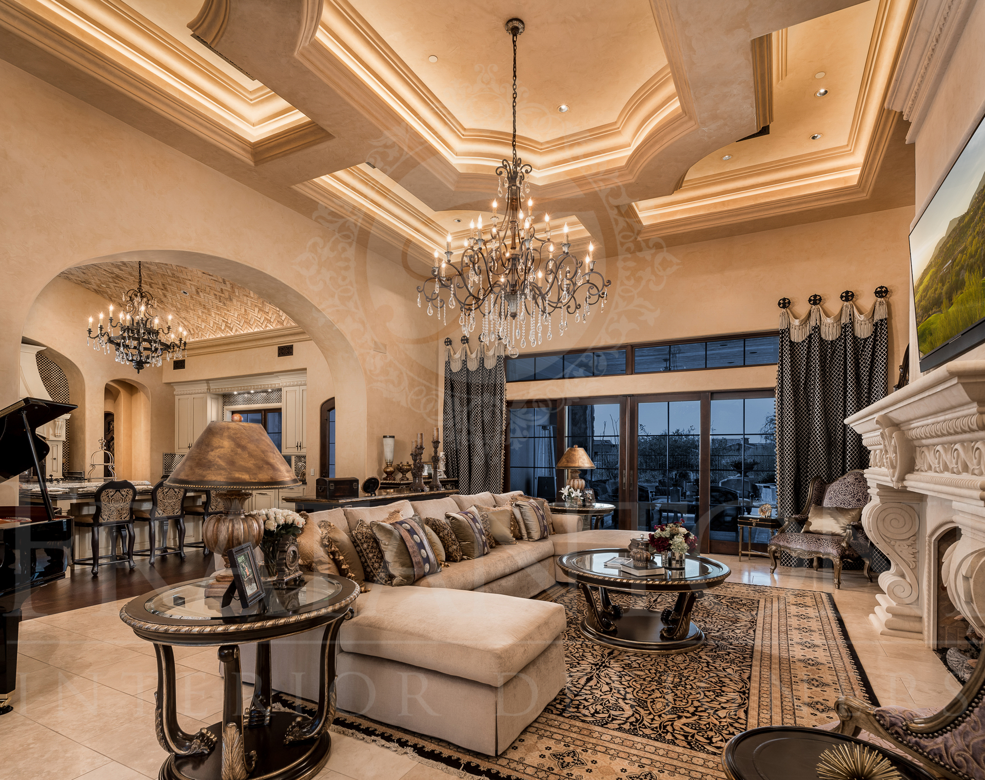 Luxurious living room with ornate ceiling, chandelier, large sofa, and fireplace.