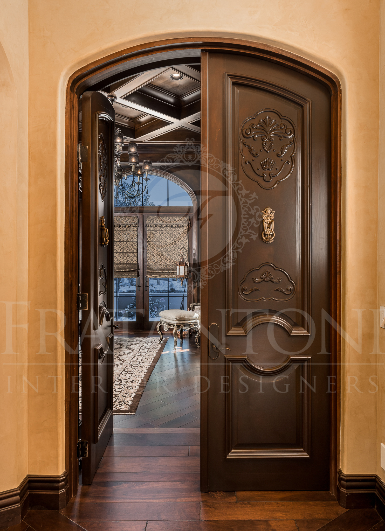 Ornate, dark wooden double doors open into a luxury home.