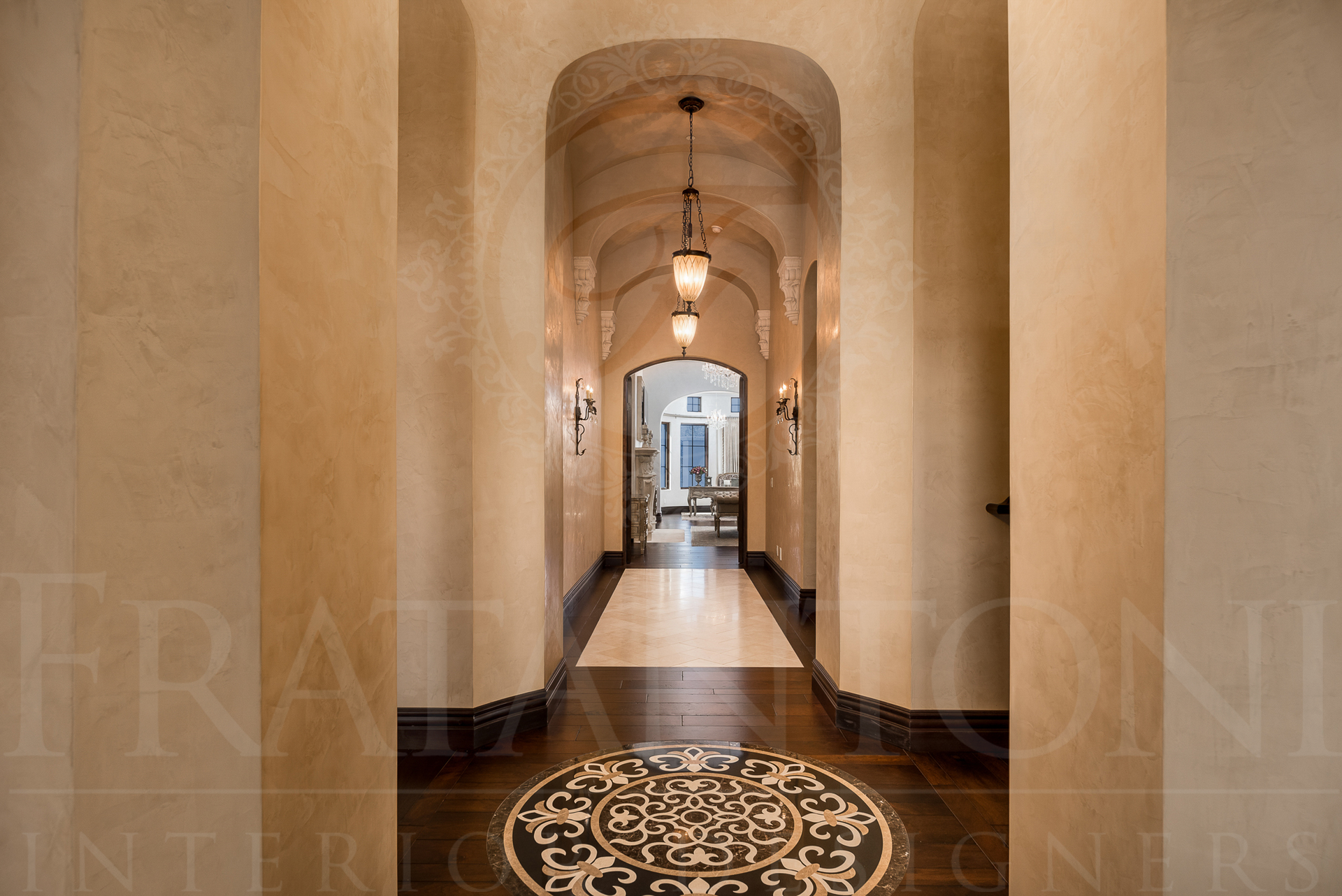 Long hallway with arch ceiling, ornate tile floor, pendant lights, and columns.