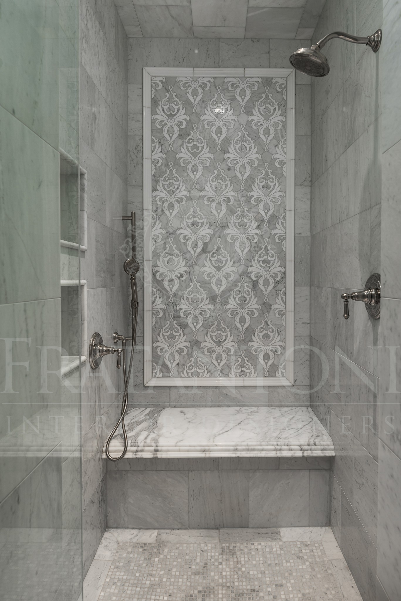 Marble shower with decorative inlay, built-in bench, and multiple showerheads.