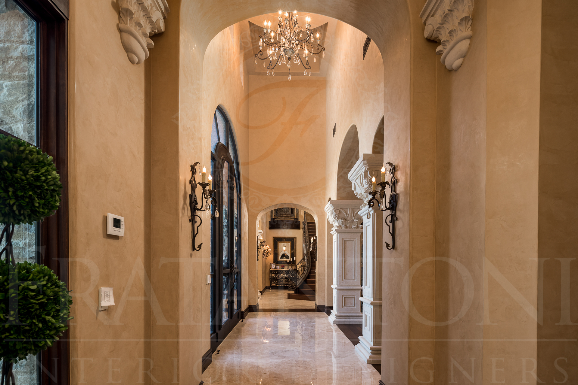 Long hallway with arched doorways, ornate light fixtures, and marble flooring.