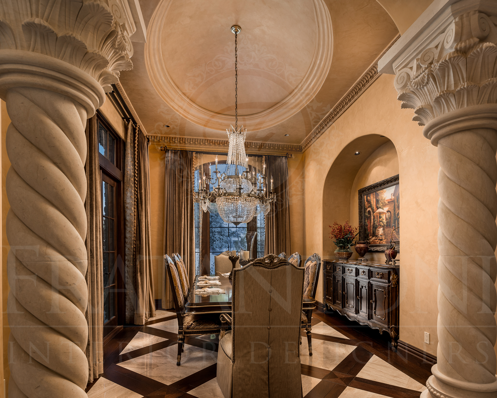 Elegant dining room with chandelier, marble columns, dark wood floors, and a decorative cabinet.