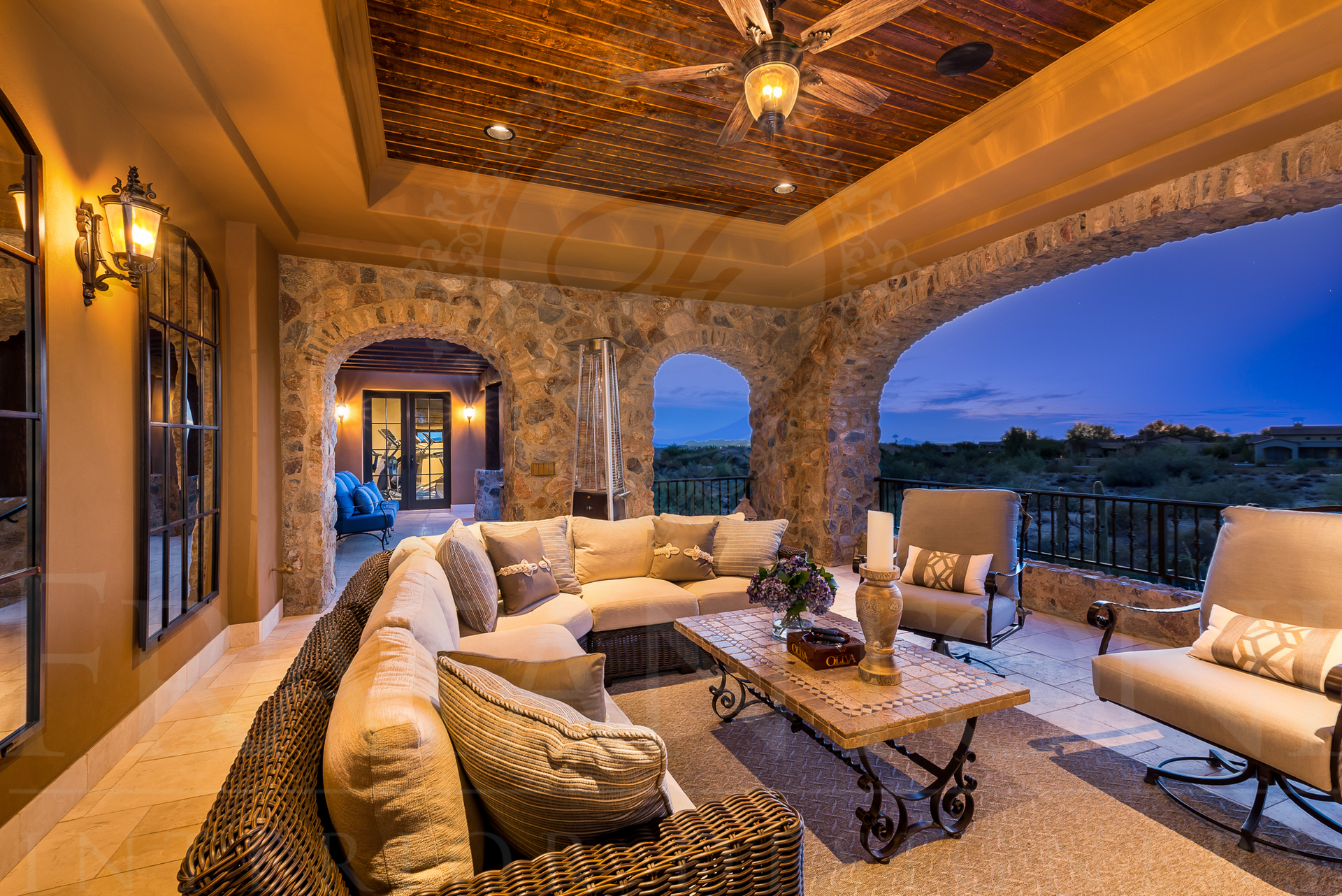 Luxurious outdoor patio with stone arches, large sectional sofa, and starry ceiling.