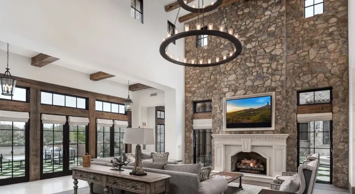 Living room with stone accent wall, fireplace, and large windows.