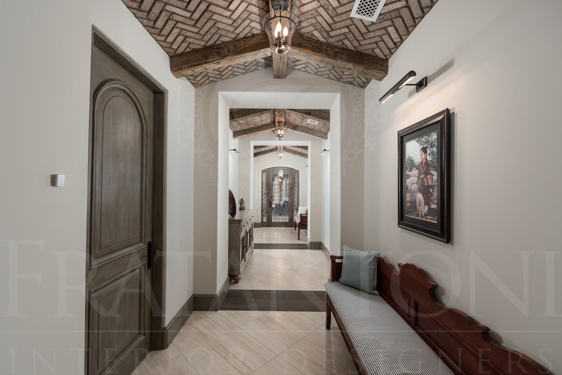 Hallway with arched doorways, herringbone brick ceiling with exposed beams, artwork, and bench with white print cushion designed by Fratantoni Interior Designers in scottsdale, arizona