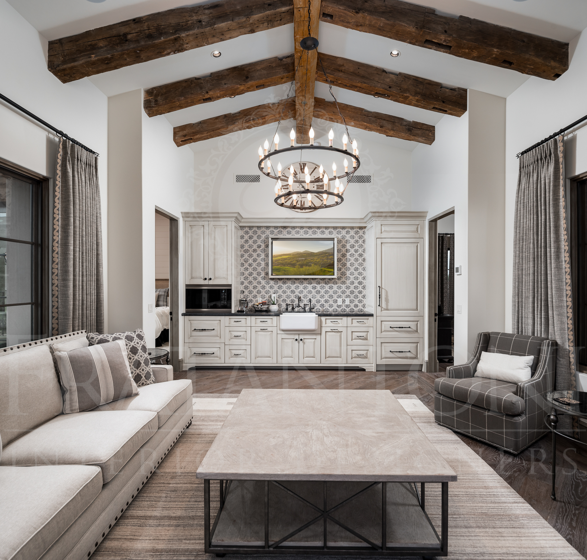 Casita great room with vaulted ceiling, exposed beams, kitchenette, and seating.