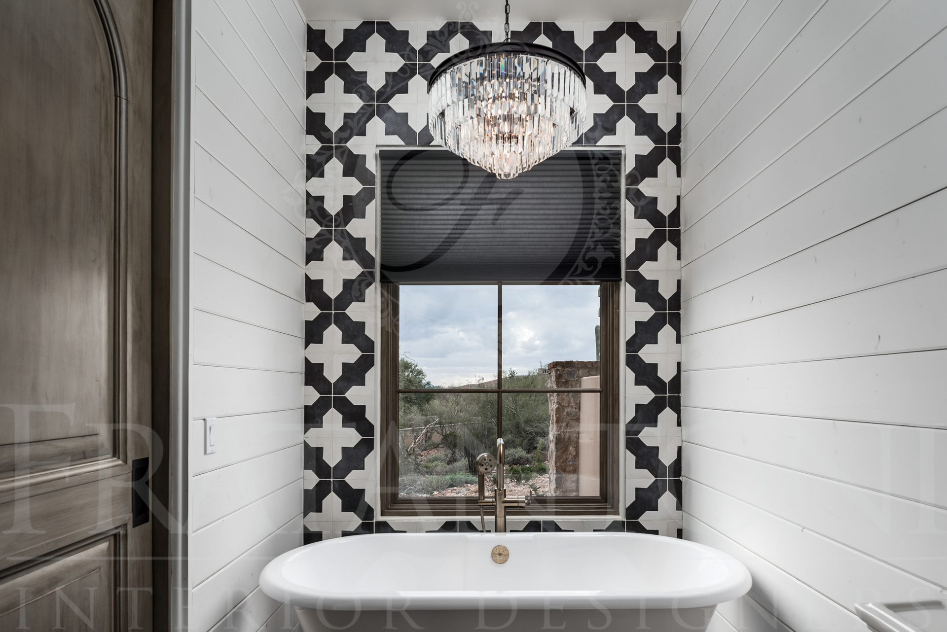Bathroom with patterned tile accent wall, window, chandelier, and clawfoot tub designed by fratantoni interior designers in scottsdale Arizona