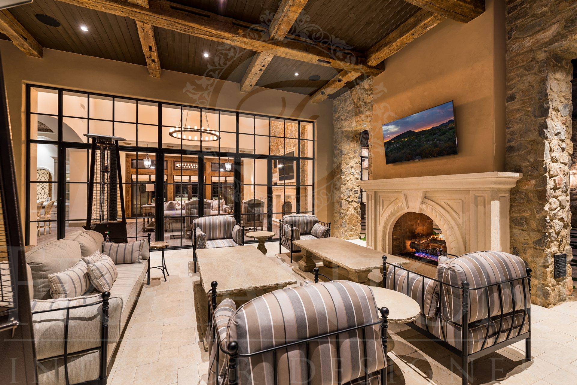 Luxurious outdoor living room with stone fireplace, sofas, and large windows designed by Fratantoni Interior Designers in scottsdale arizona
