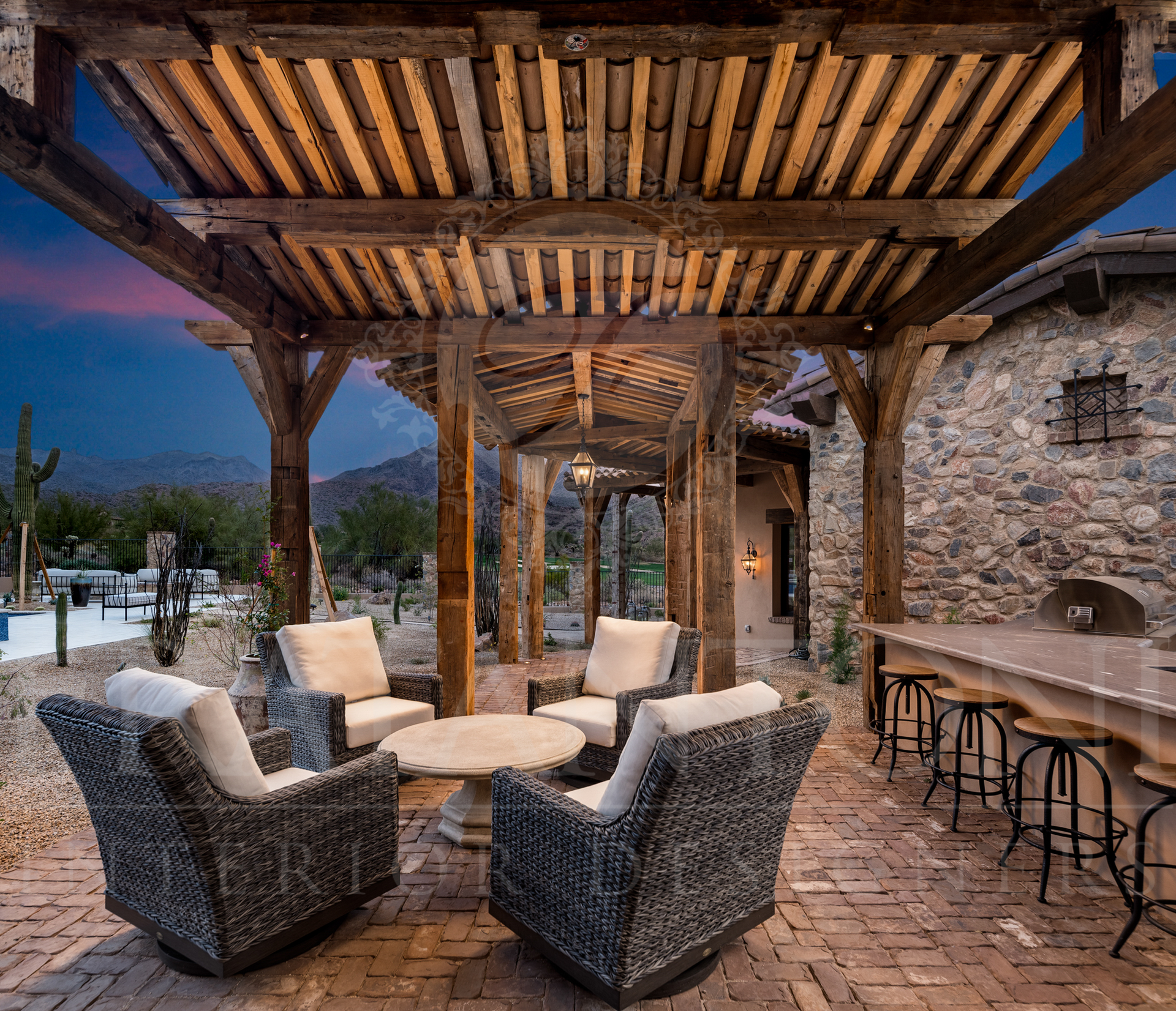 Outdoor covered patio with seating area, stone building, wooden pergola, and bar designed by Fratantoni Interior Designers in scottsdale, arizona 
