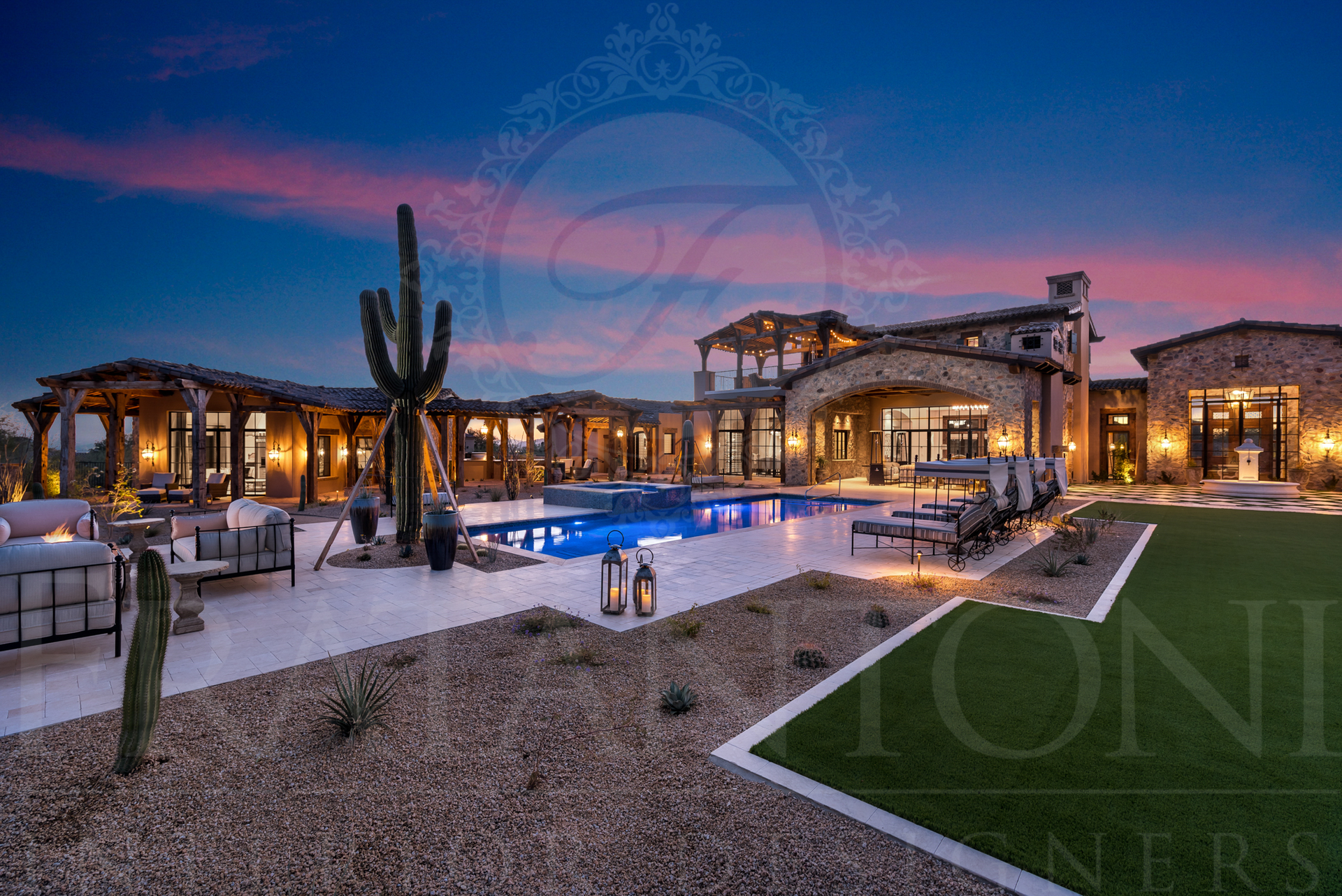 Luxury mansion exterior with pool and desert landscaping at dusk.