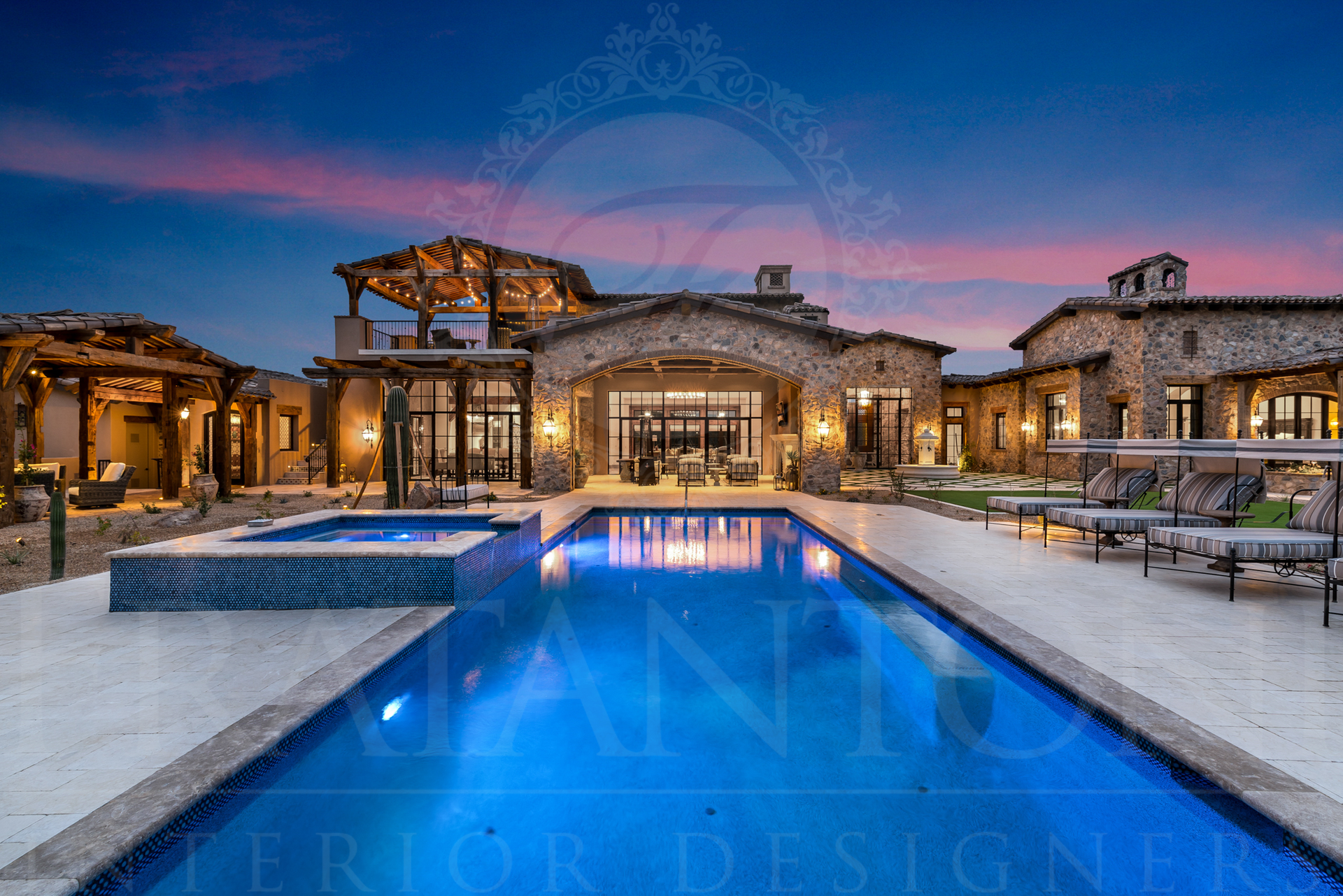 Luxury home with resort-style pool at dusk; stone facade, open-air cabana, and lounge chairs.