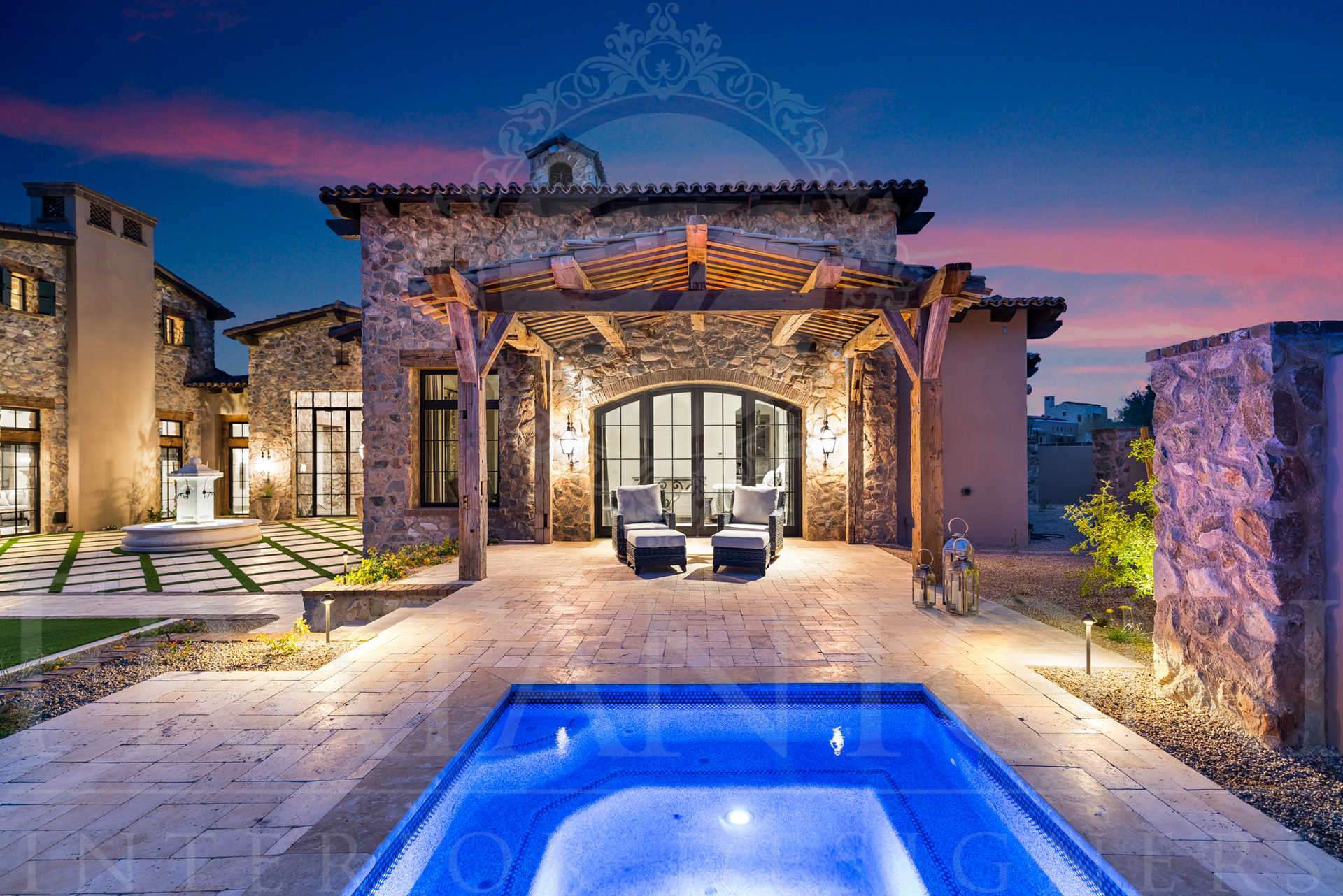 Luxury home exterior at dusk, featuring a private primary suite pool, stone facade, and illuminated patio designed by Fratantoni Interior Designers in Scottsdale, arizona. 