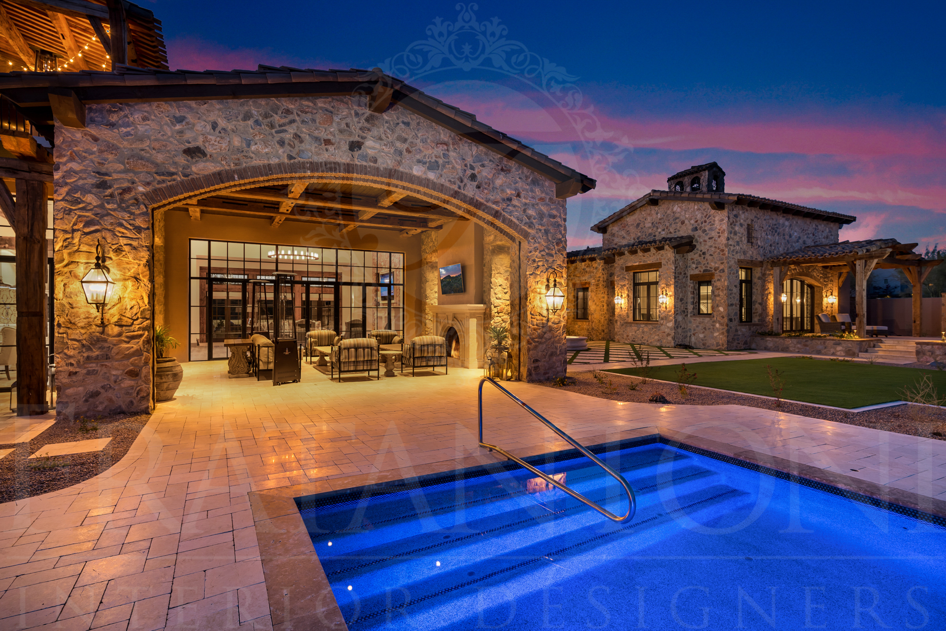 Luxury arizona home exterior with a pool, patio, and stone architecture at dusk.