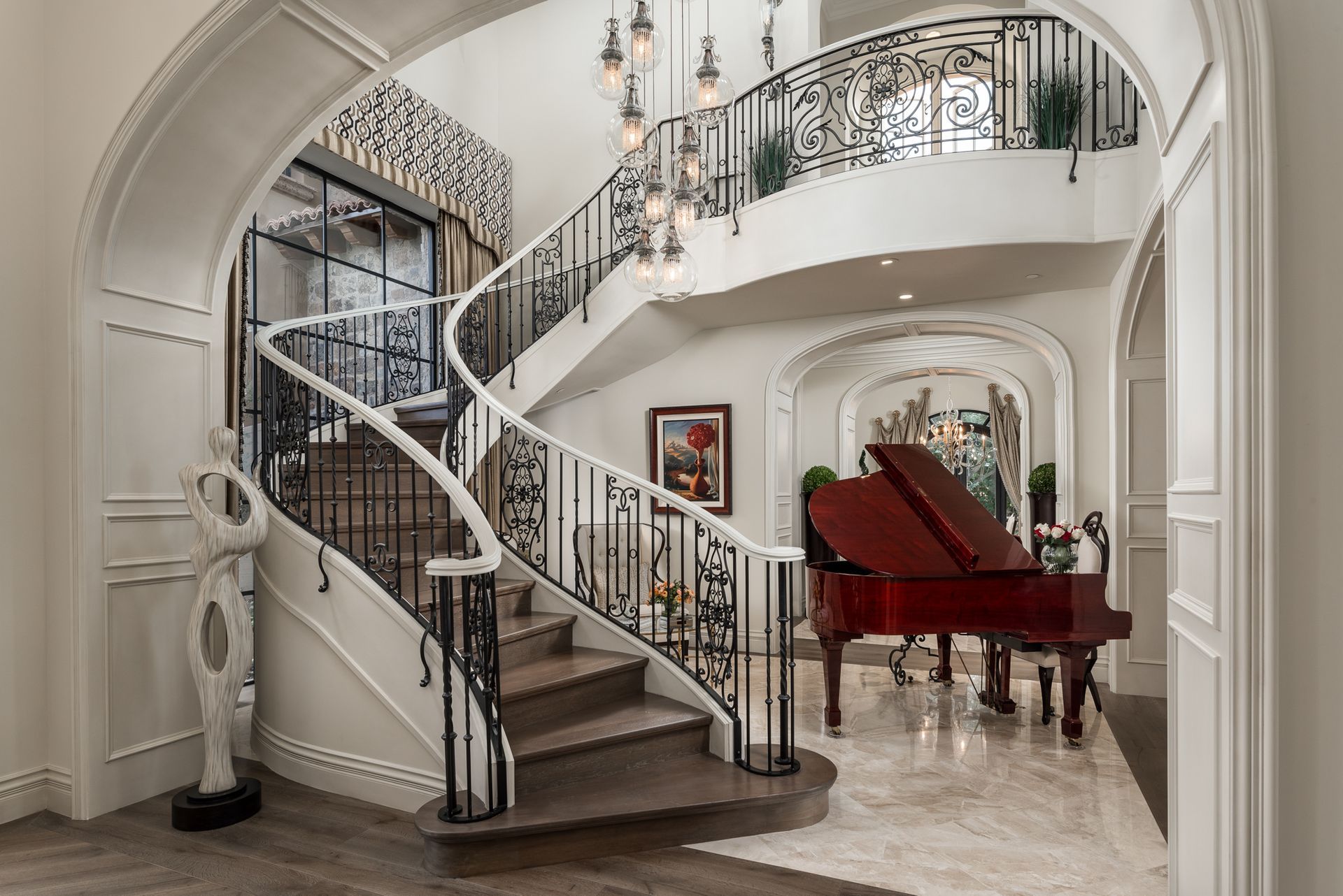 There is a grand piano in the middle of the room next to the stairs.