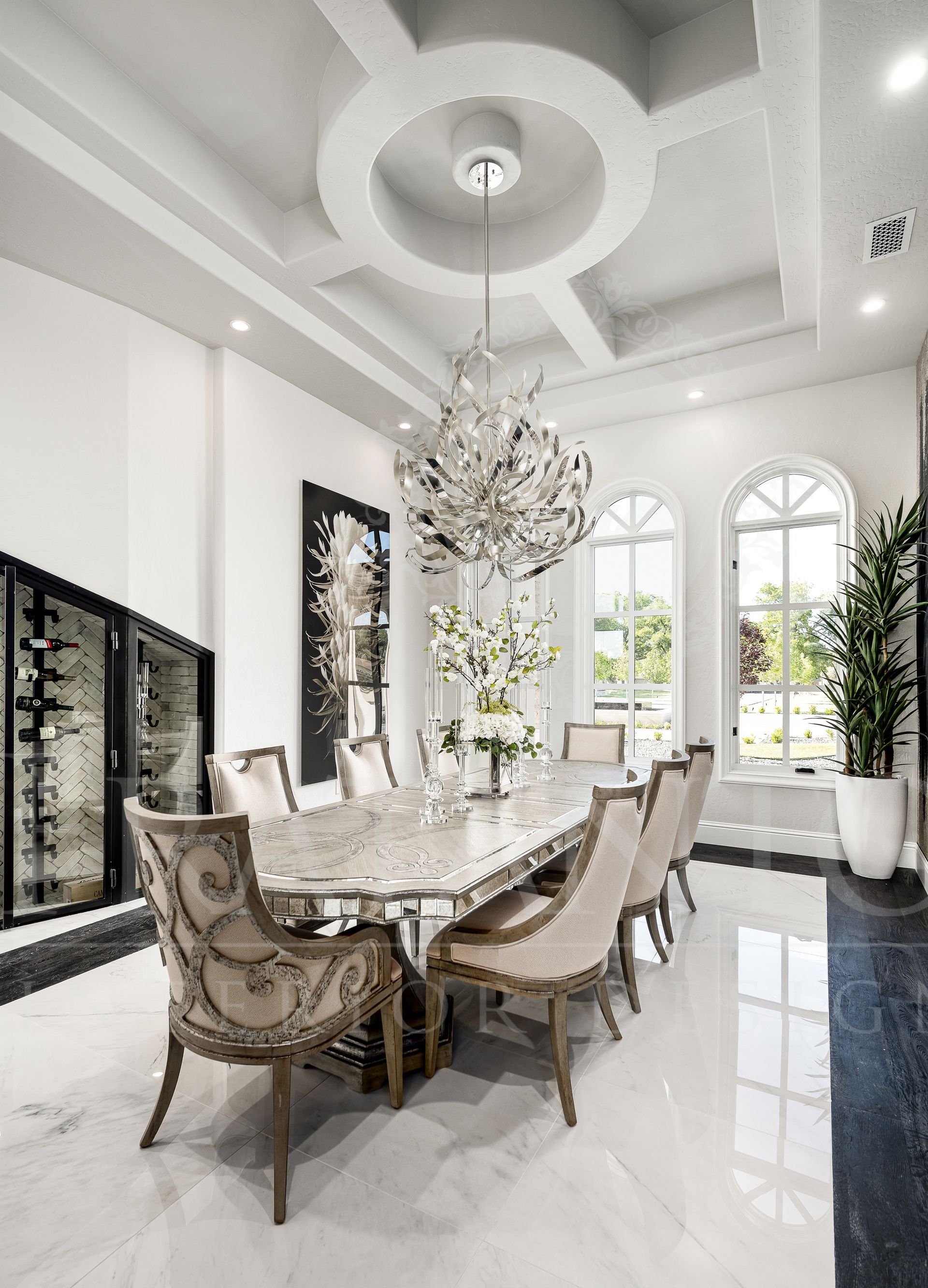 Elegant formal dining room with chandelier, marble table, upholstered chairs, and tall windows.