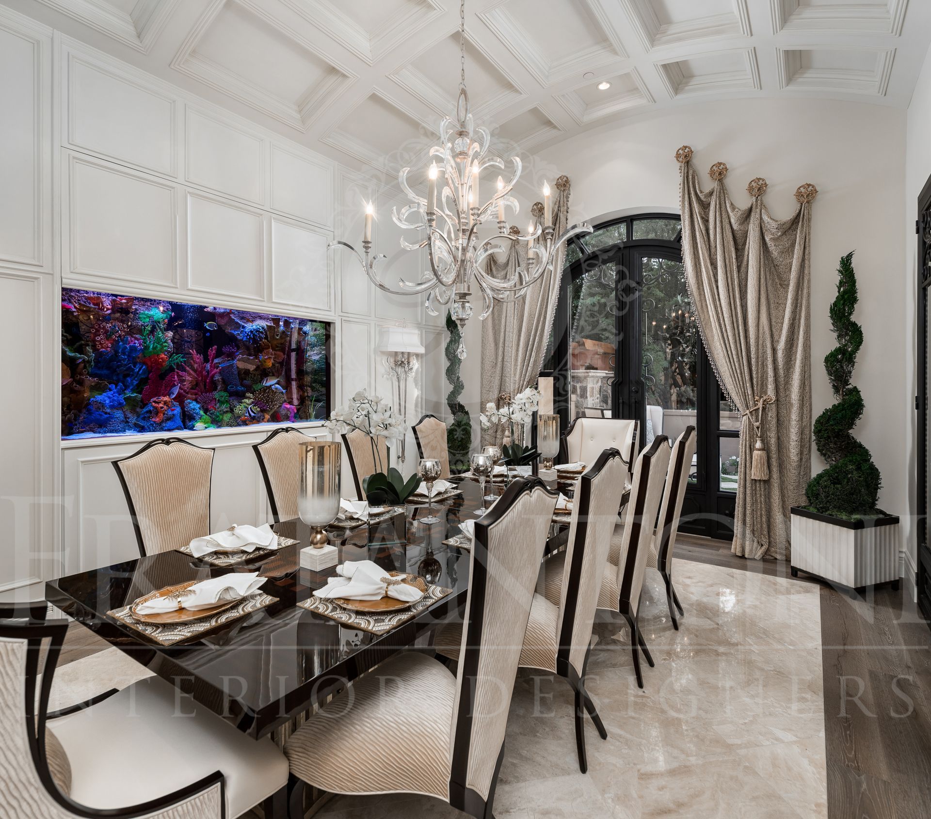 Elegant formal dining room with chandelier, long table set for a meal, large custom aquarium, and ornate ceiling designed by Fratantoni Interior Designers.