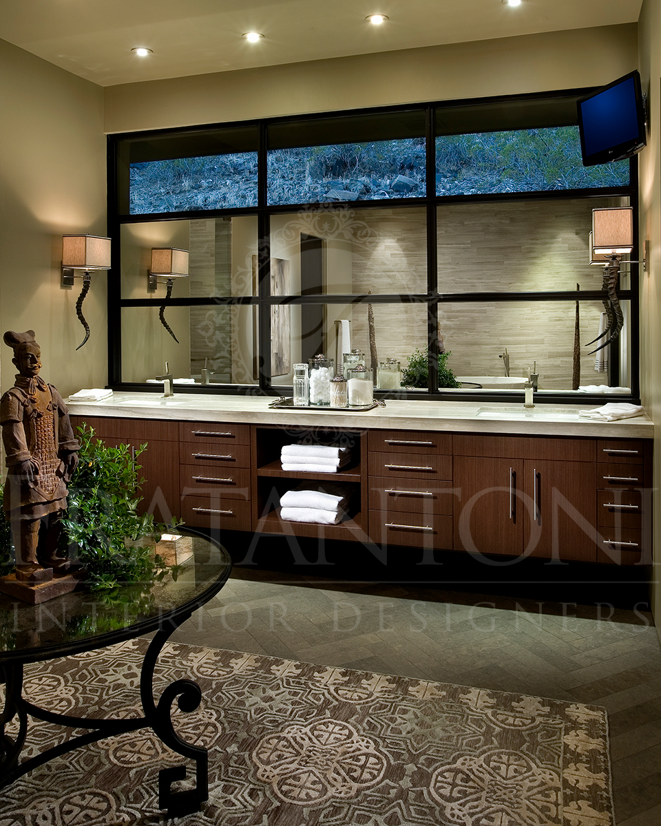 A modern bathroom featuring a dark wood vanity, a large gridded mirror, dual sinks, and an ornate table in the foreground.