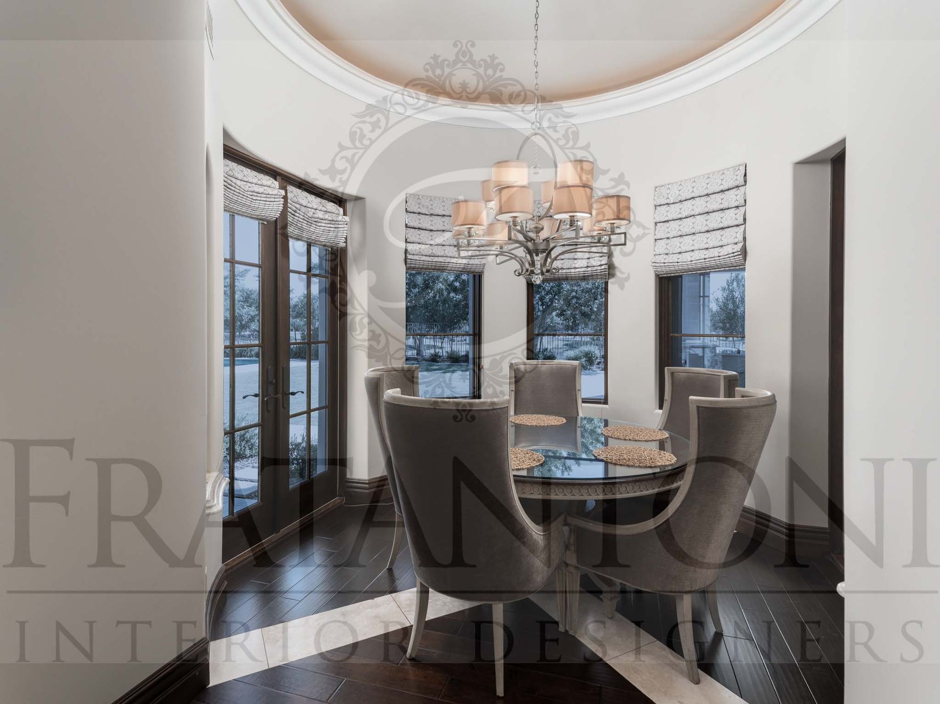 Elegant breakfast nook with chandelier, round table, and tall windows with desert view