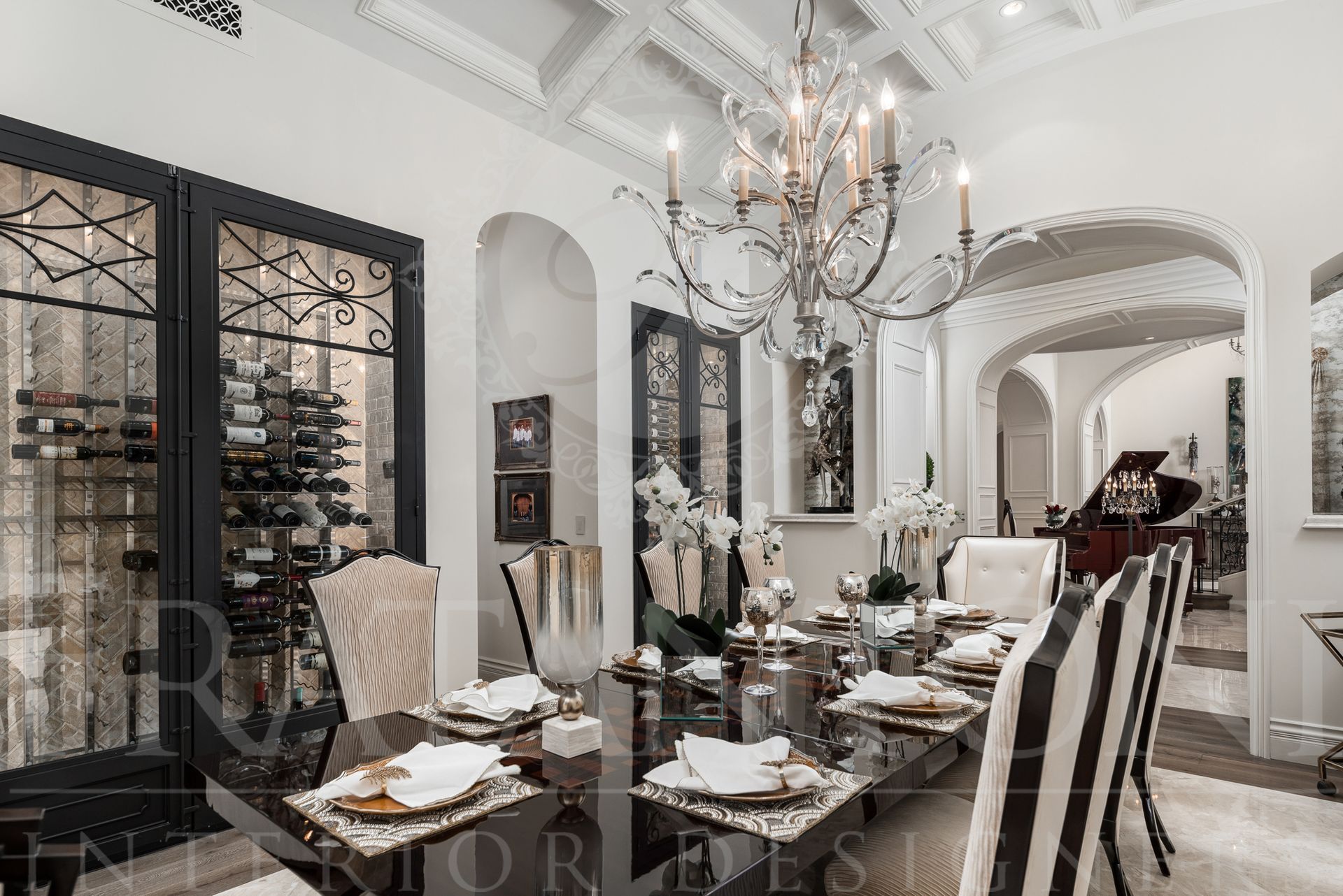 Formal dining room with black table, ornate chandelier, wine cabinets, arched doorways, and custom chairs.