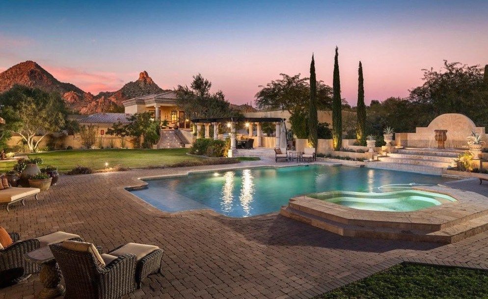A large swimming pool with a hot tub in the middle of it