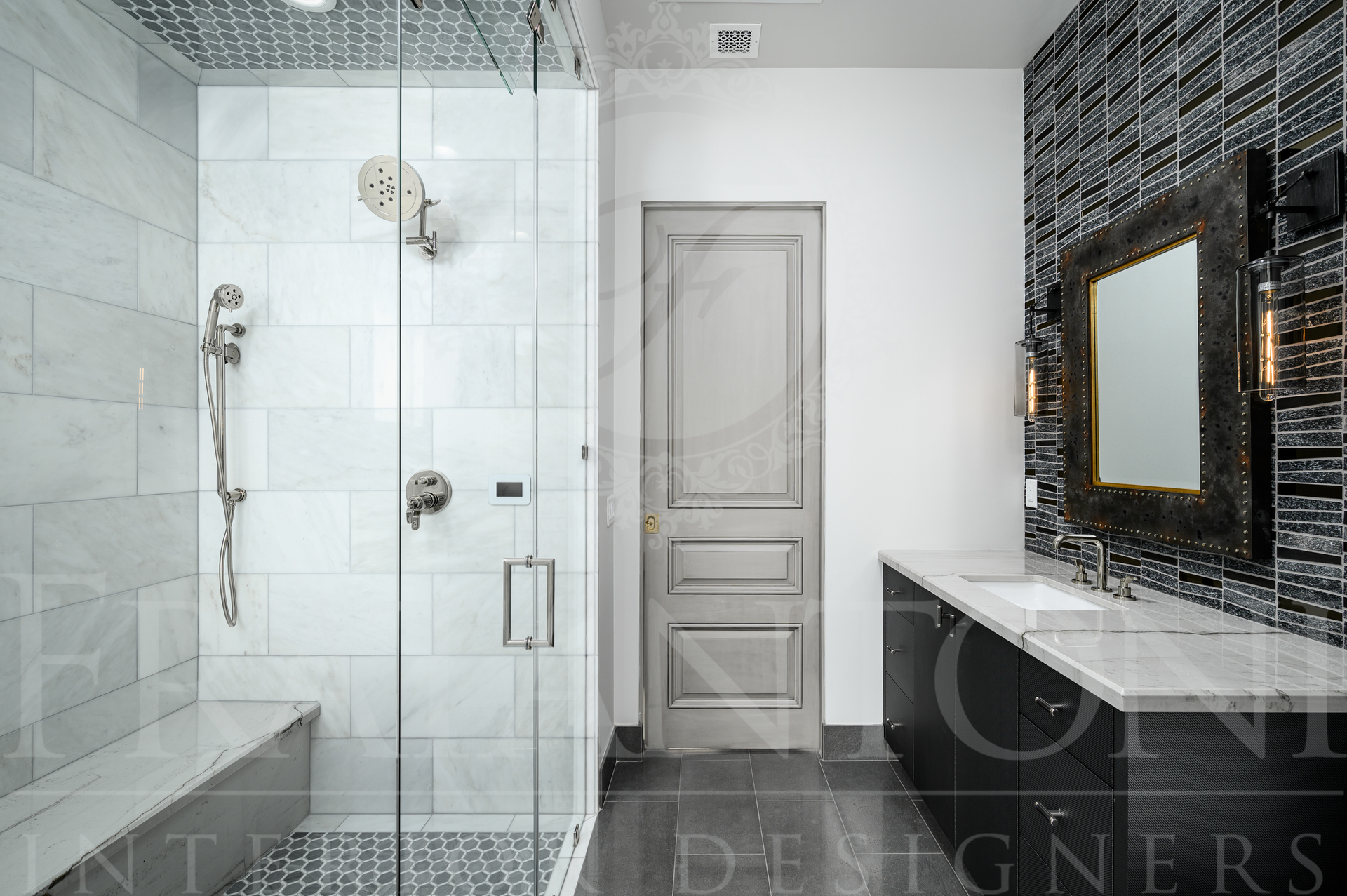 Modern luxury bathroom with glass shower, black tile accents, black vanity, mosaic floor tiles, and marble countertops in Scottsdale, Arizona.