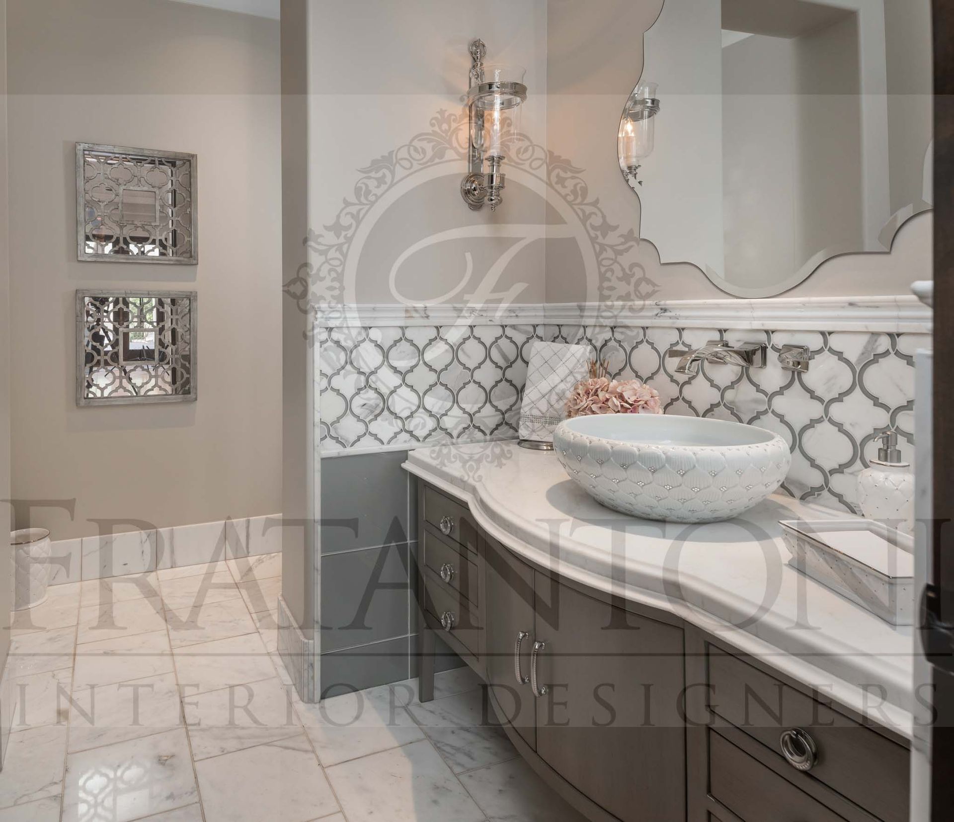 Elegant bathroom vanity with a large mirror, wall sconces, patterned tile backsplash, and vessel sink.