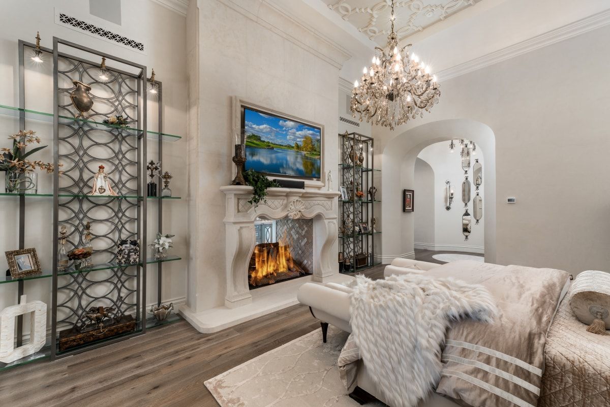 Elegant living room with fireplace, shelving, and chandelier.