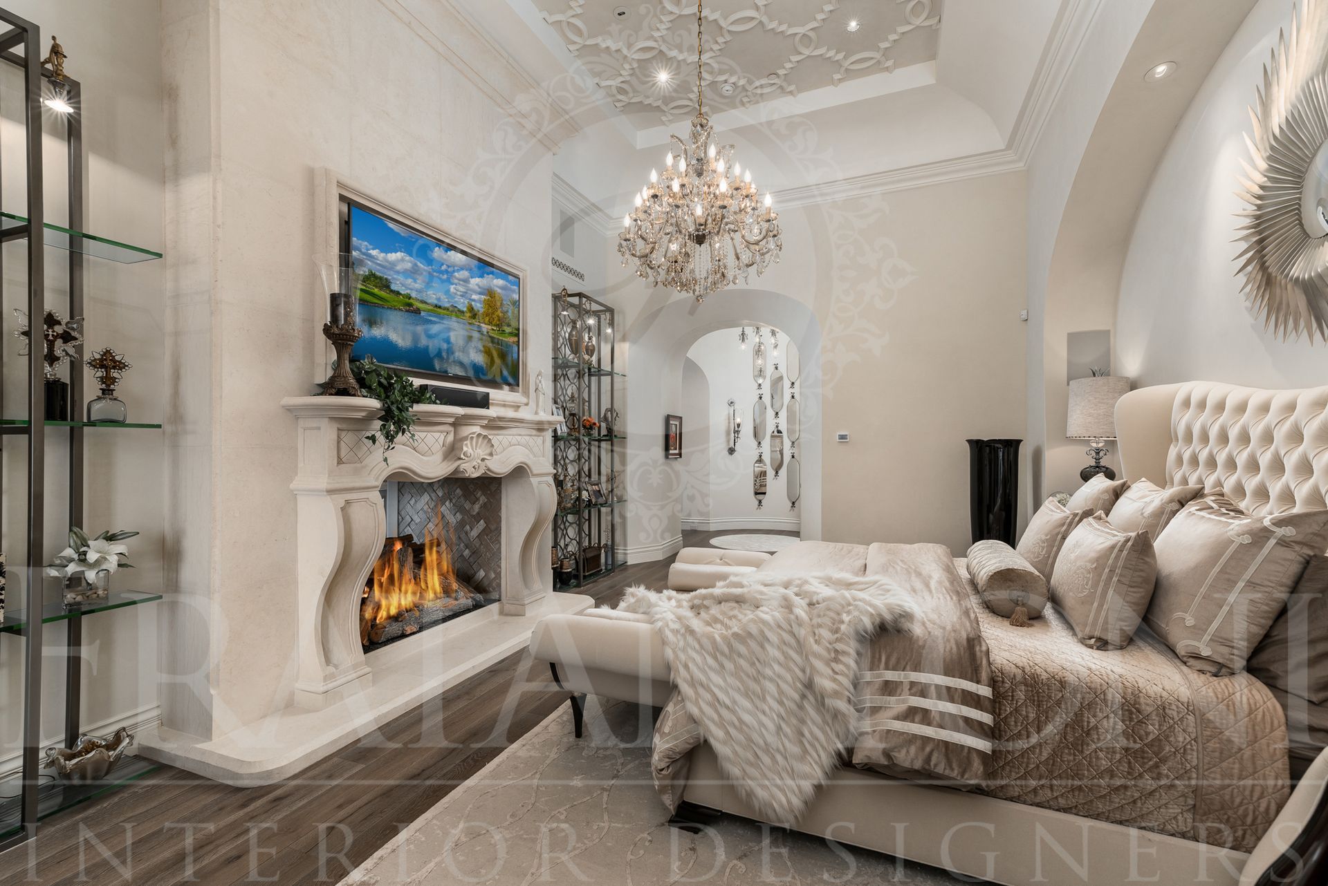 Luxury neutral master bedroom with fireplace, chandelier, and elegant furniture.