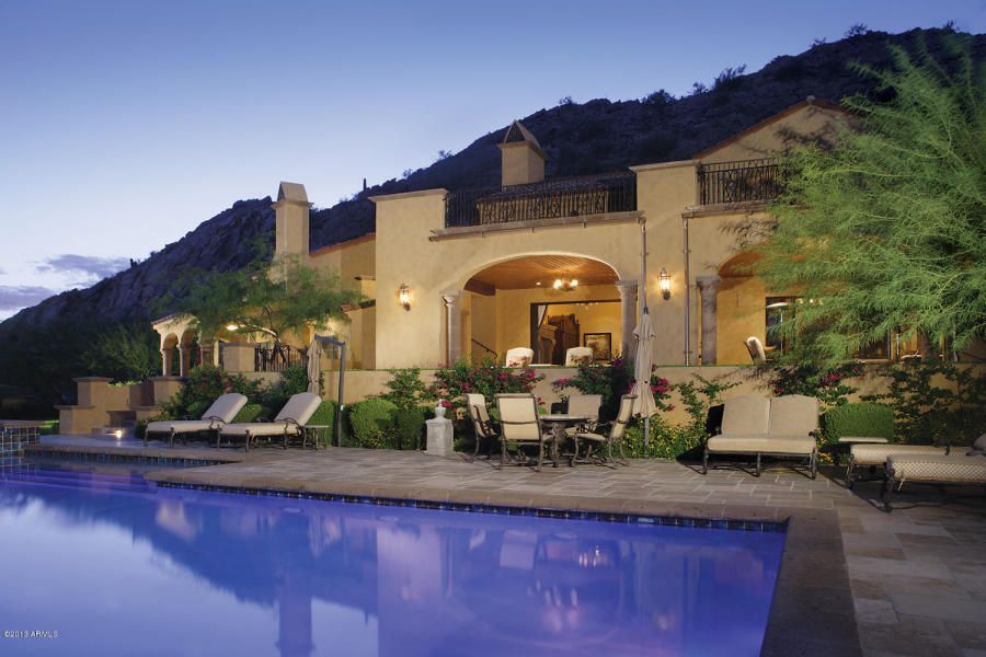A large house with a swimming pool in front of it