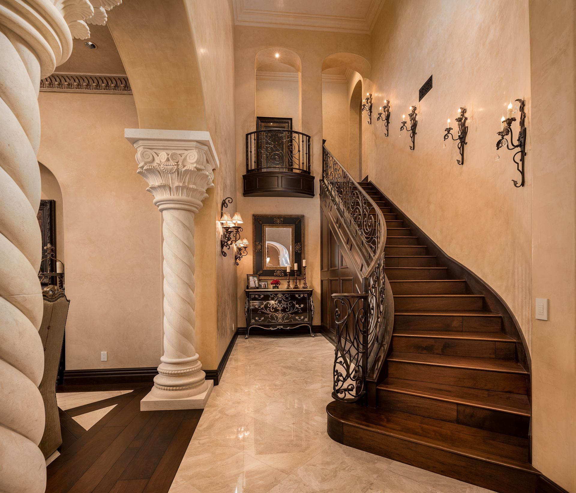 A staircase with a wrought iron railing in a hallway