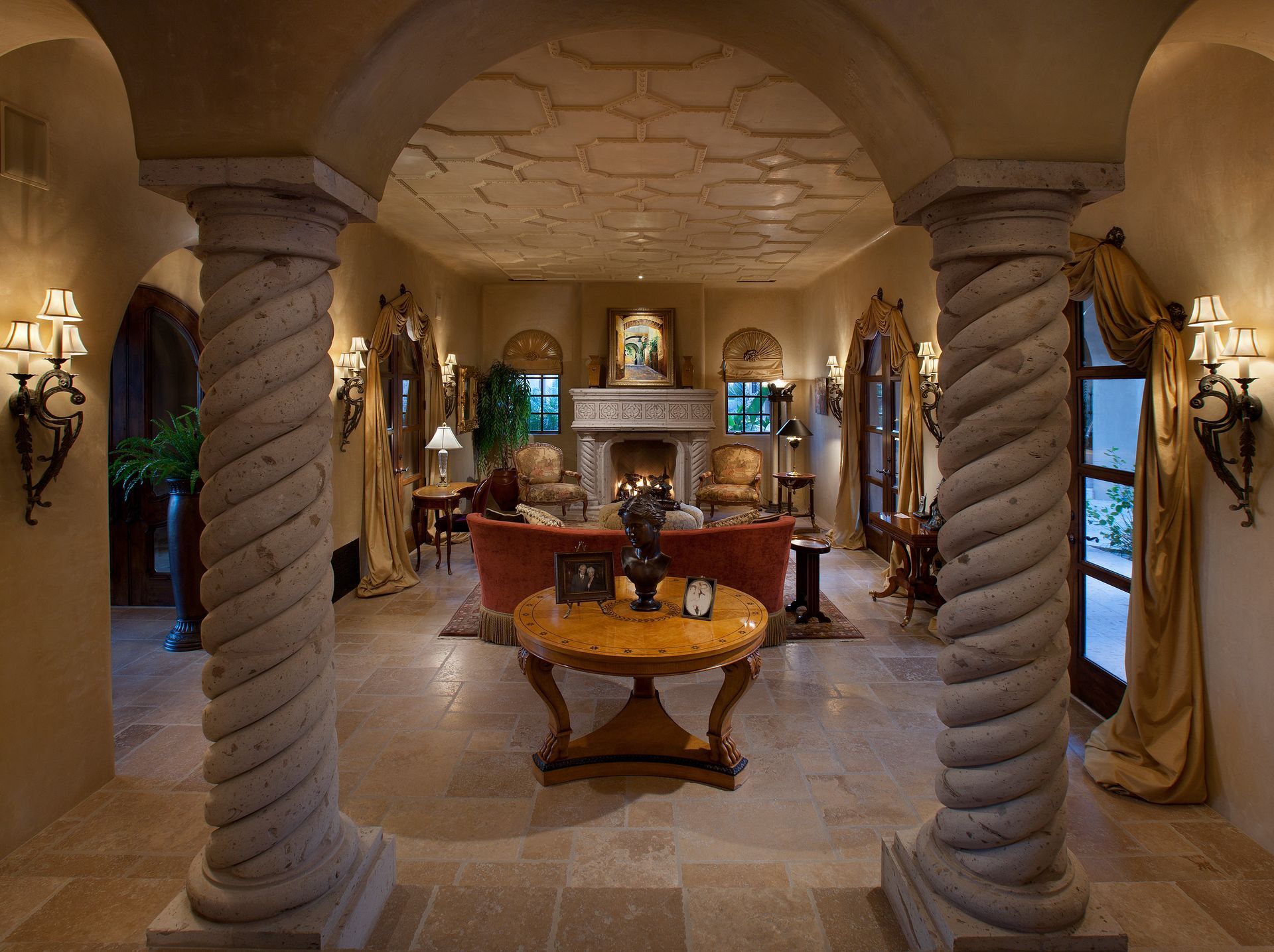A living room with columns and a table in the middle
