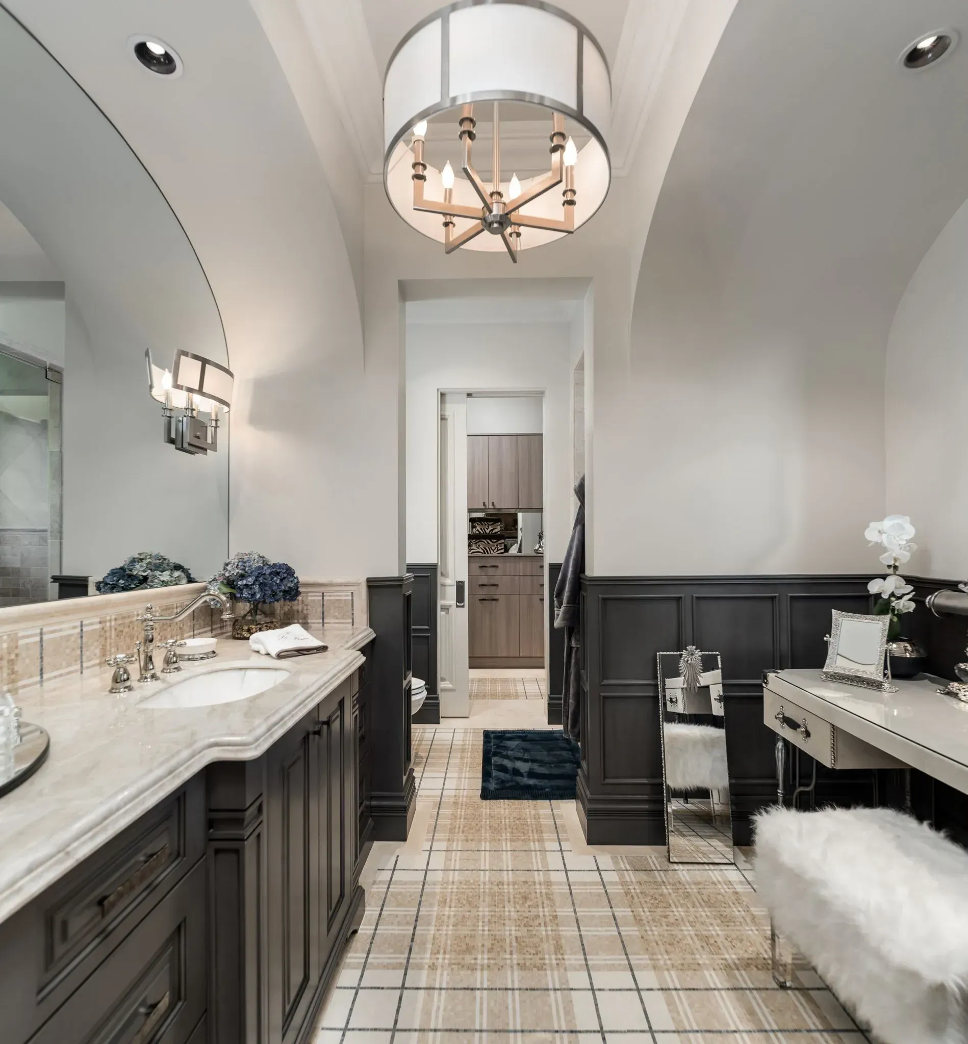 Elegant bathroom with arched ceiling, dark wood cabinets, and a plaid tile floor.