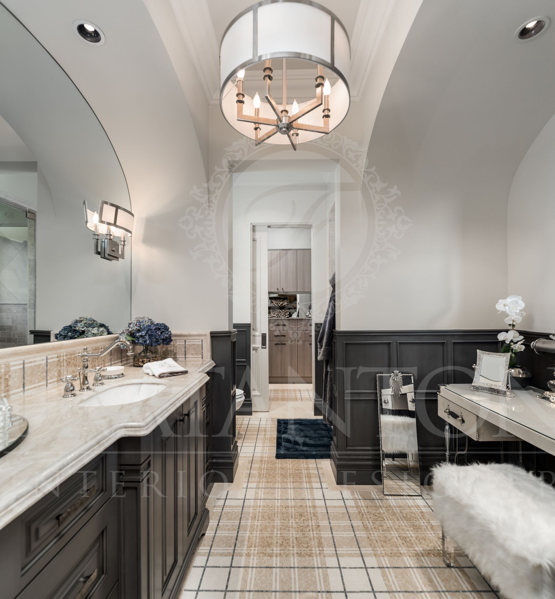 Bathroom with vanity, dark cabinets, plaid tile, seated makeup vanity, and a chandelier.