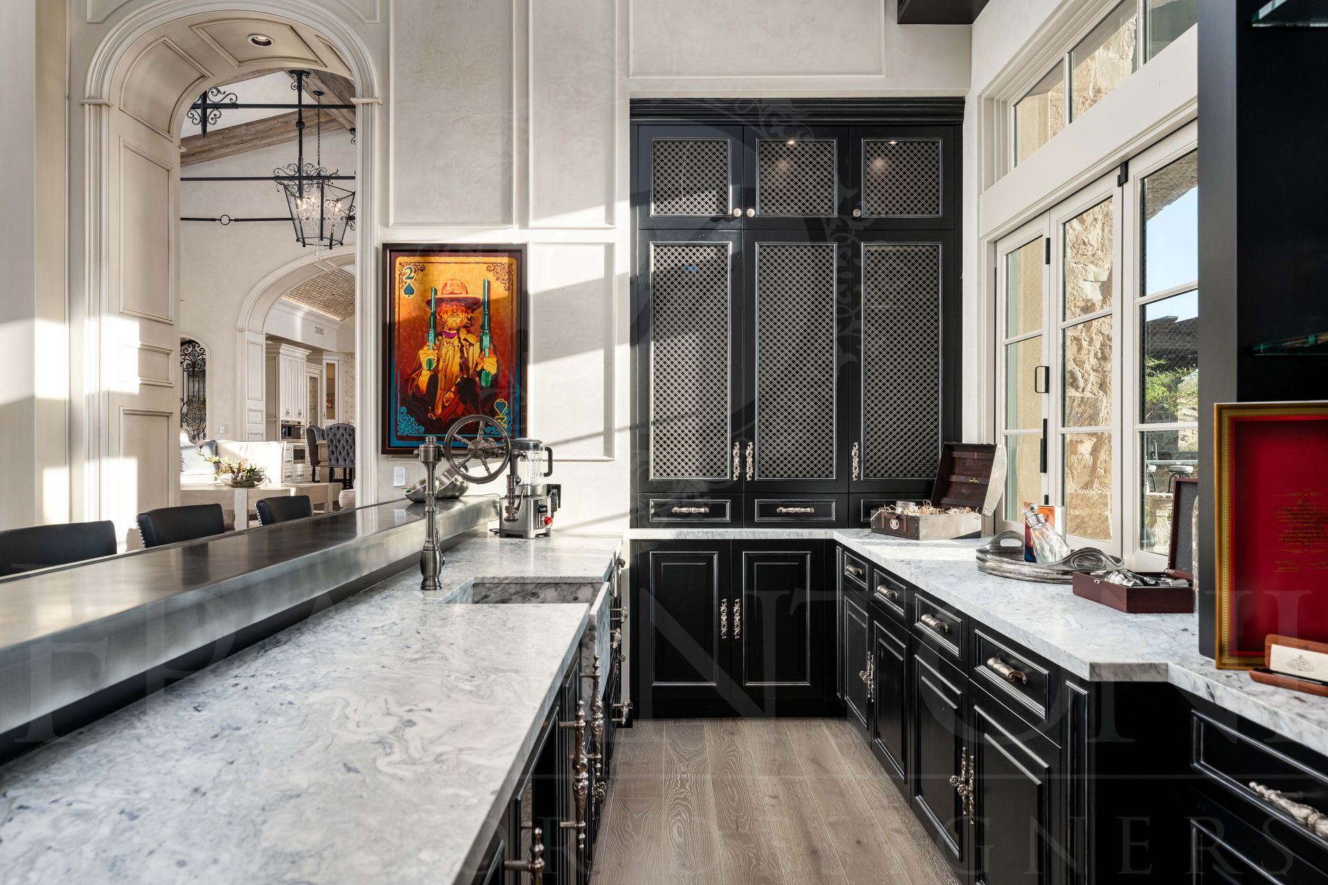 Elegant black-and-white home bar with marble island, glossy black cabinets, and large windows