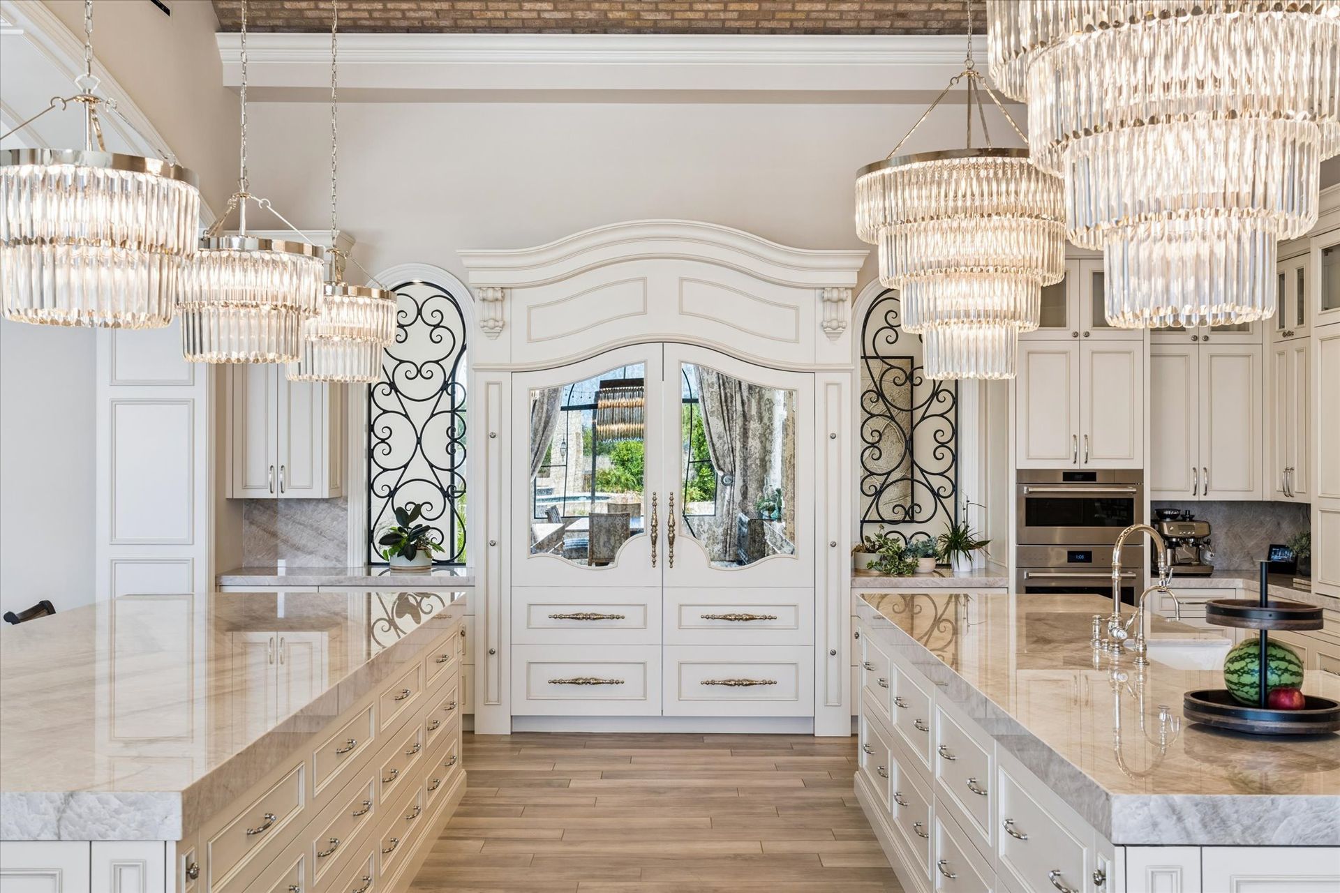 Luxury kitchen with marble islands, crystal chandeliers, and custom Fratantoni armoire hidden fridge