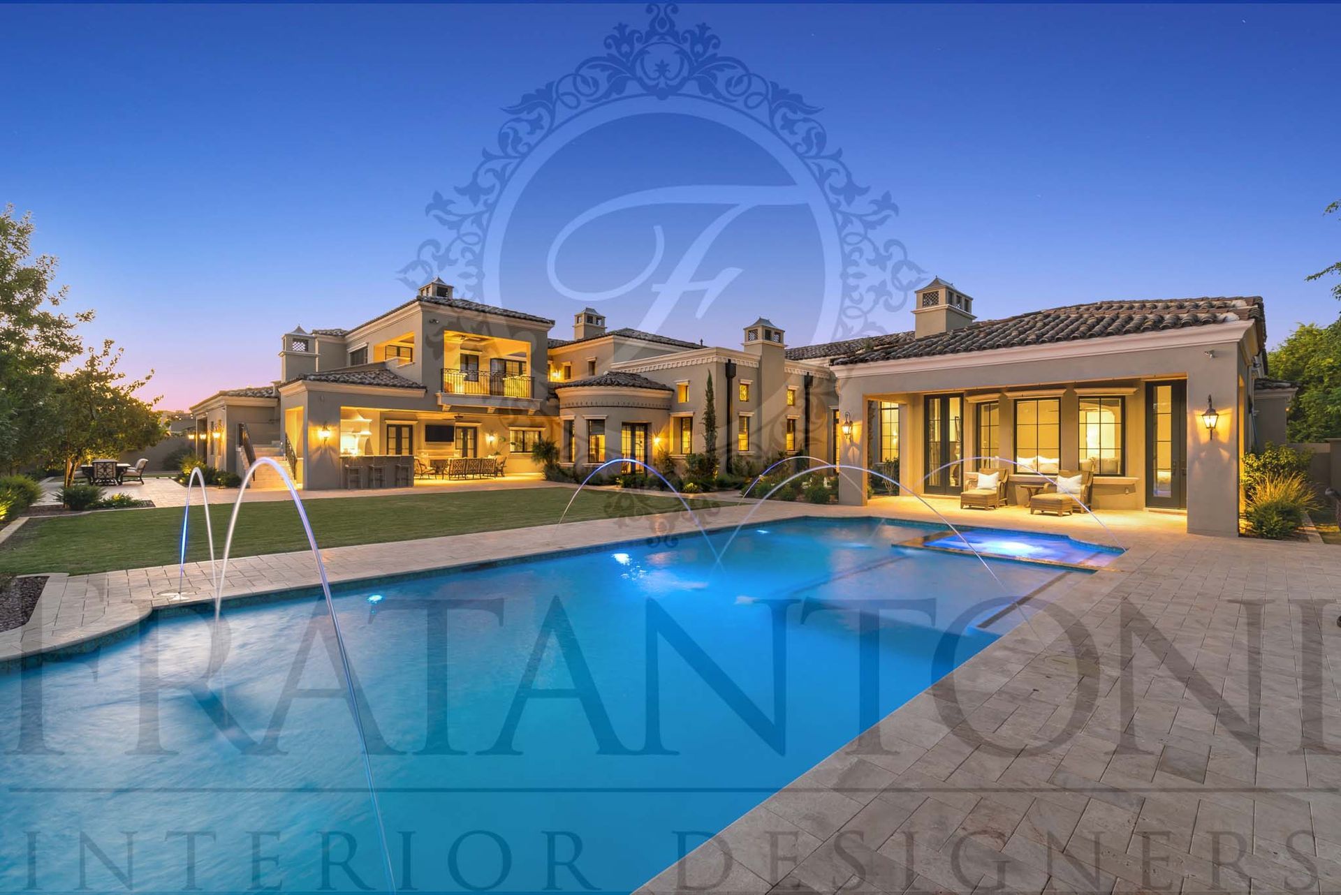 Luxury Mediterranean villa with lit resort-style pool with water features and outdoor lighting at dusk and desert-style landscaping designed by fratantoni interior designers in scottsdale arizona