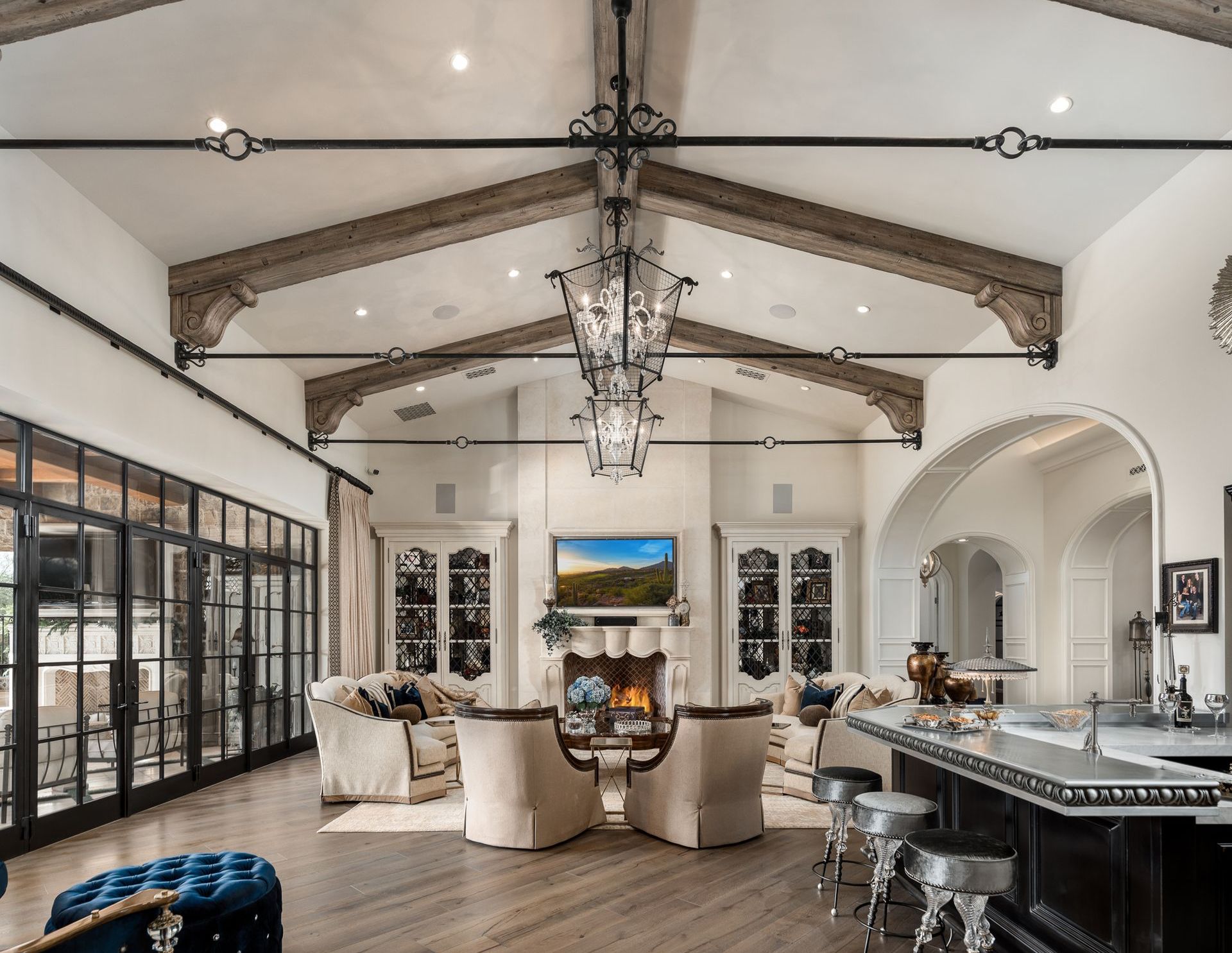Luxury living room with arched ceiling, fireplace, and ornate chandelier.