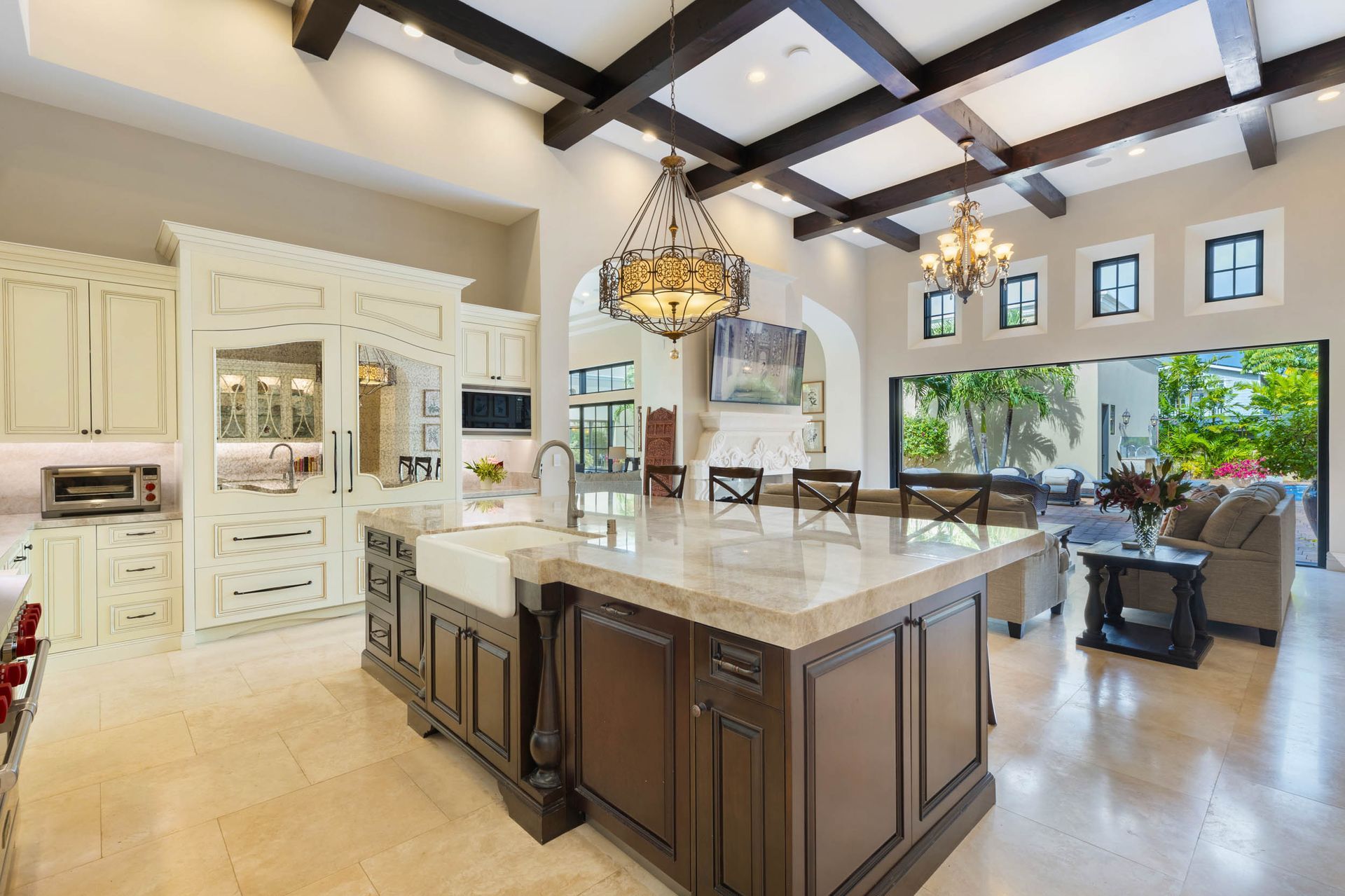 Spacious kitchen with large island, dark wood cabinets, tan countertops, and high ceilings.