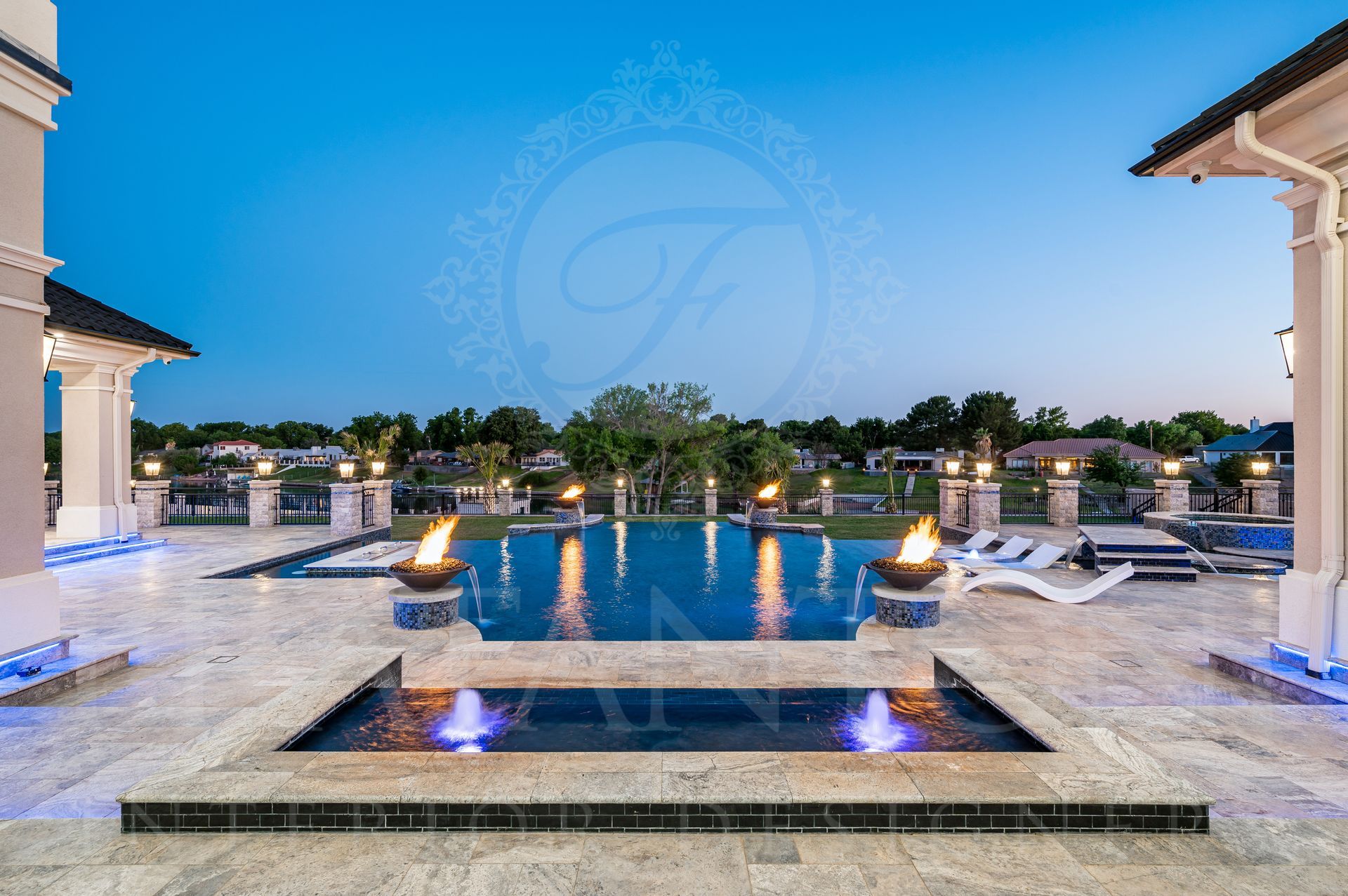 Luxury backyard pool with fire bowls and hot tub at dusk in Arizona