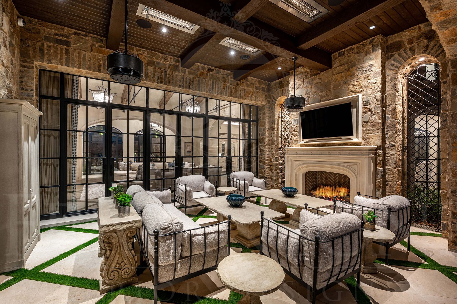 French luxury style backyard in silver leaf canyon with a wood beam ceiling, outdoor fans, custom furniture, and floor to ceiling windows and iron glass French doors