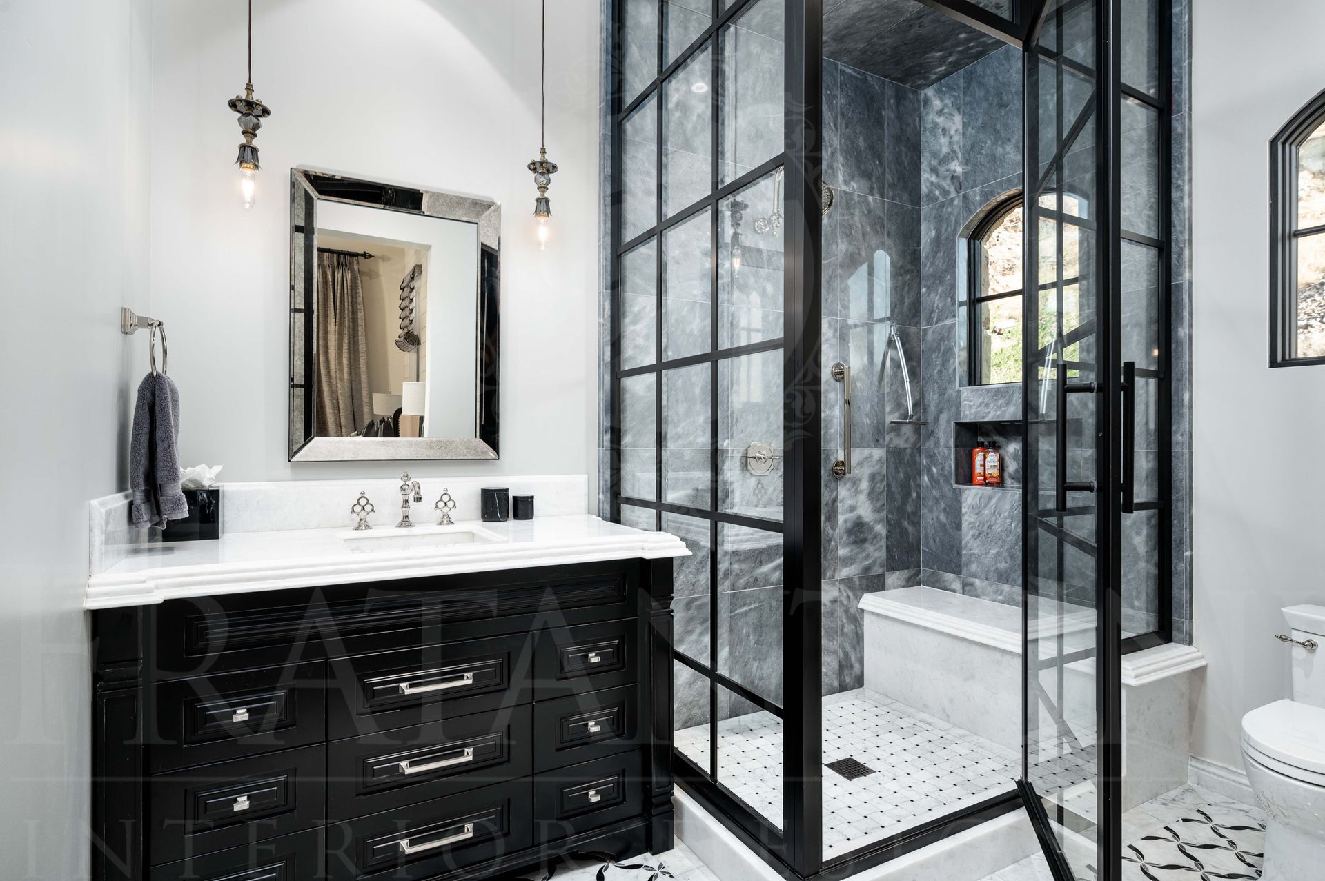 Modern black-and-white bathroom with vanity, mirror, and glass shower enclosure with grey stone shower slabs and a built-in shower-niche.