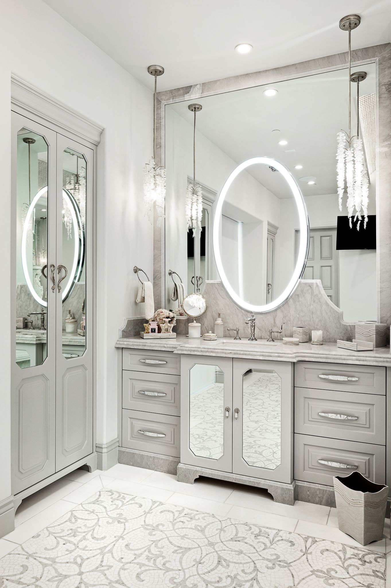 Elegant white bathroom with vanity, mirrors, and crystal pendant lights.