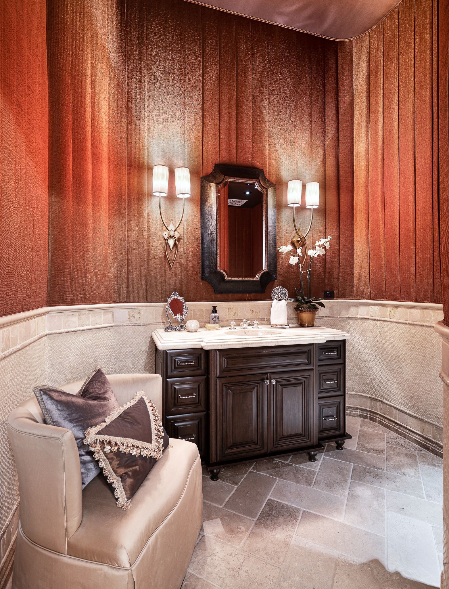 Luxurious bathroom with dark wood vanity, patterned walls, and a curved, tiled wall.