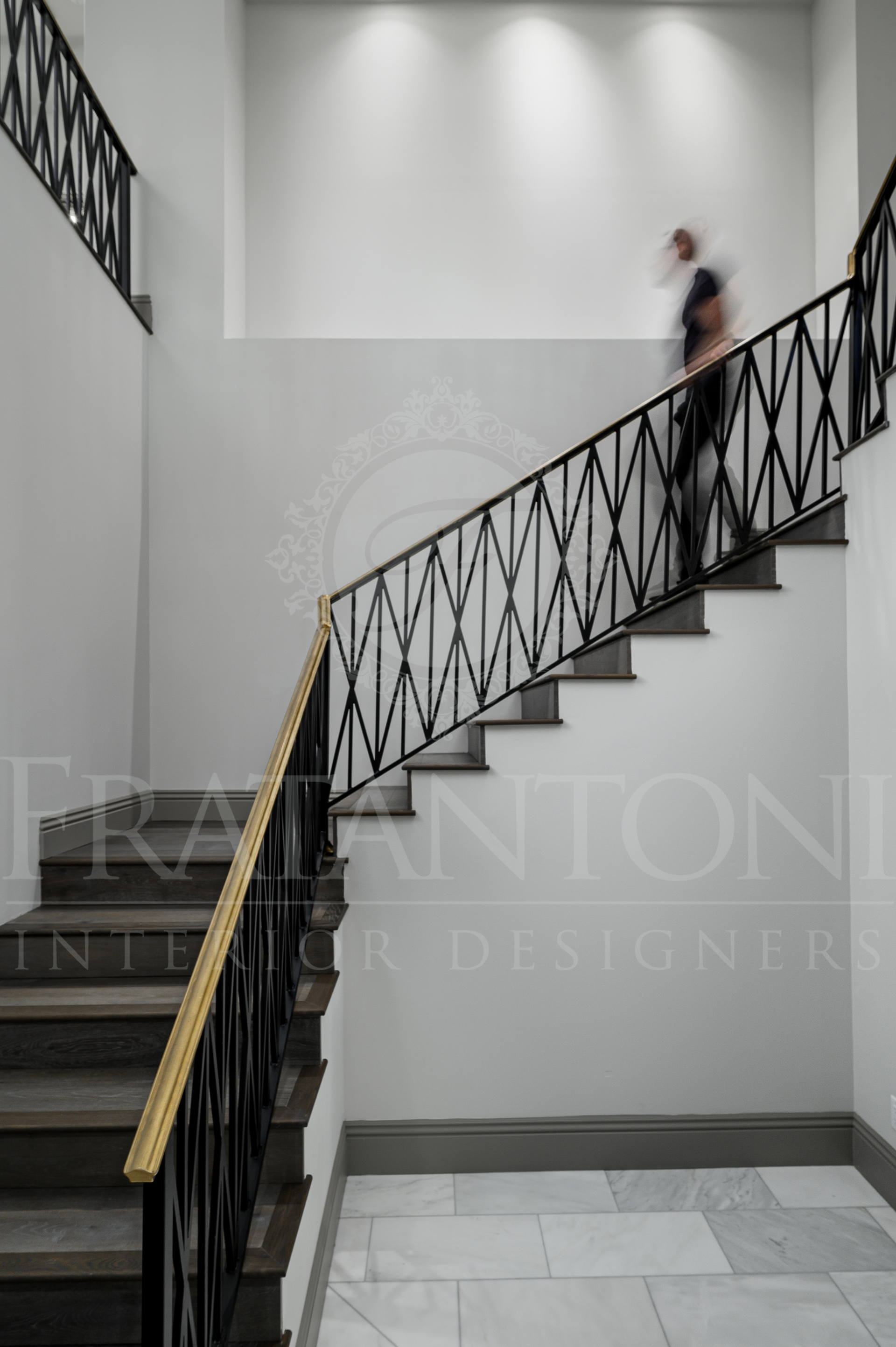 Custom staircase with black iron railing and white walls in a bright entry, custom designed by luxury interior designers in scottsdale, Arizona