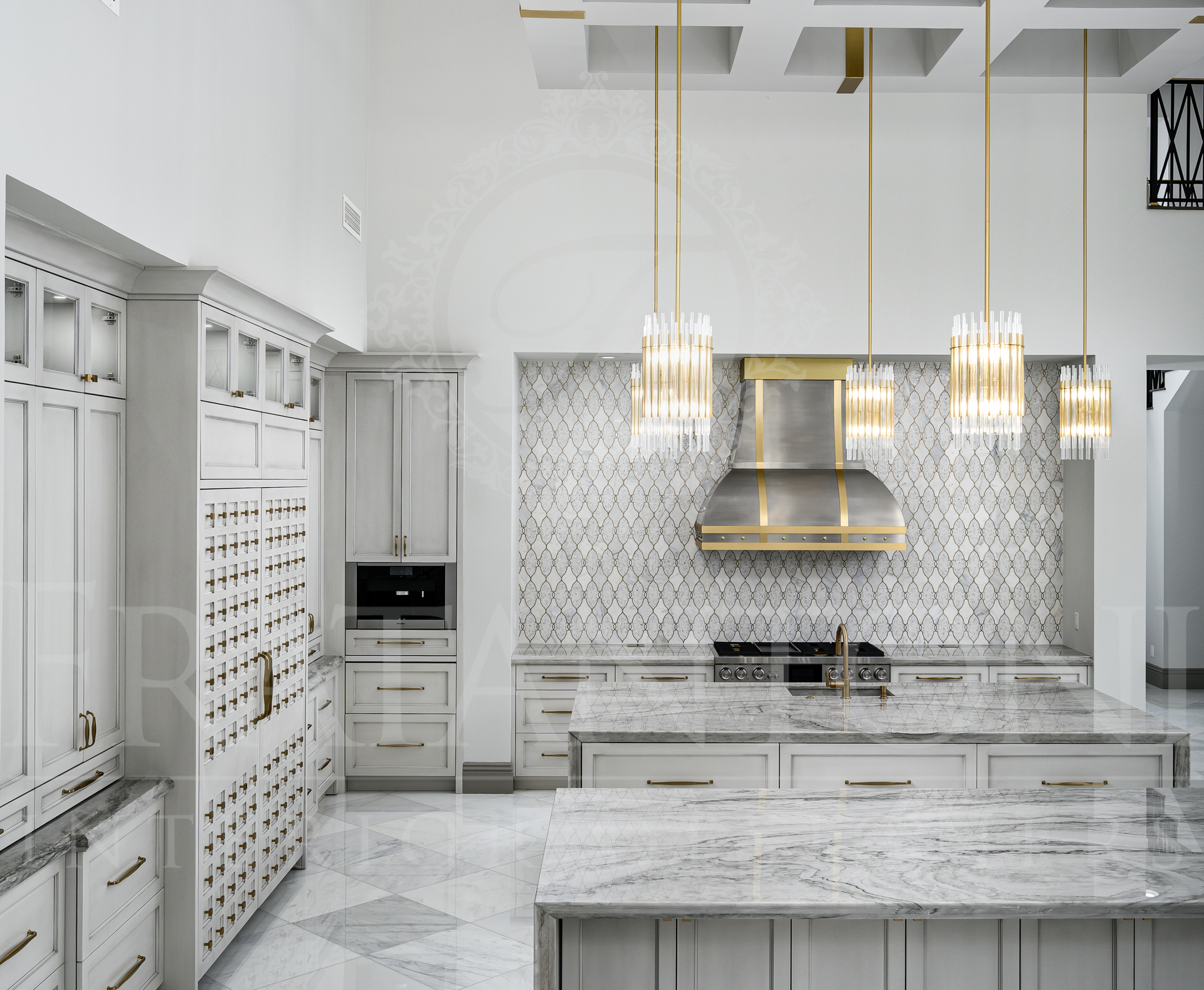 Bright white luxury modern kitchen with marble islands, mosaic backsplash, gold pendant lights, and custom built-in cabinets by Fratantoni Interior Designers