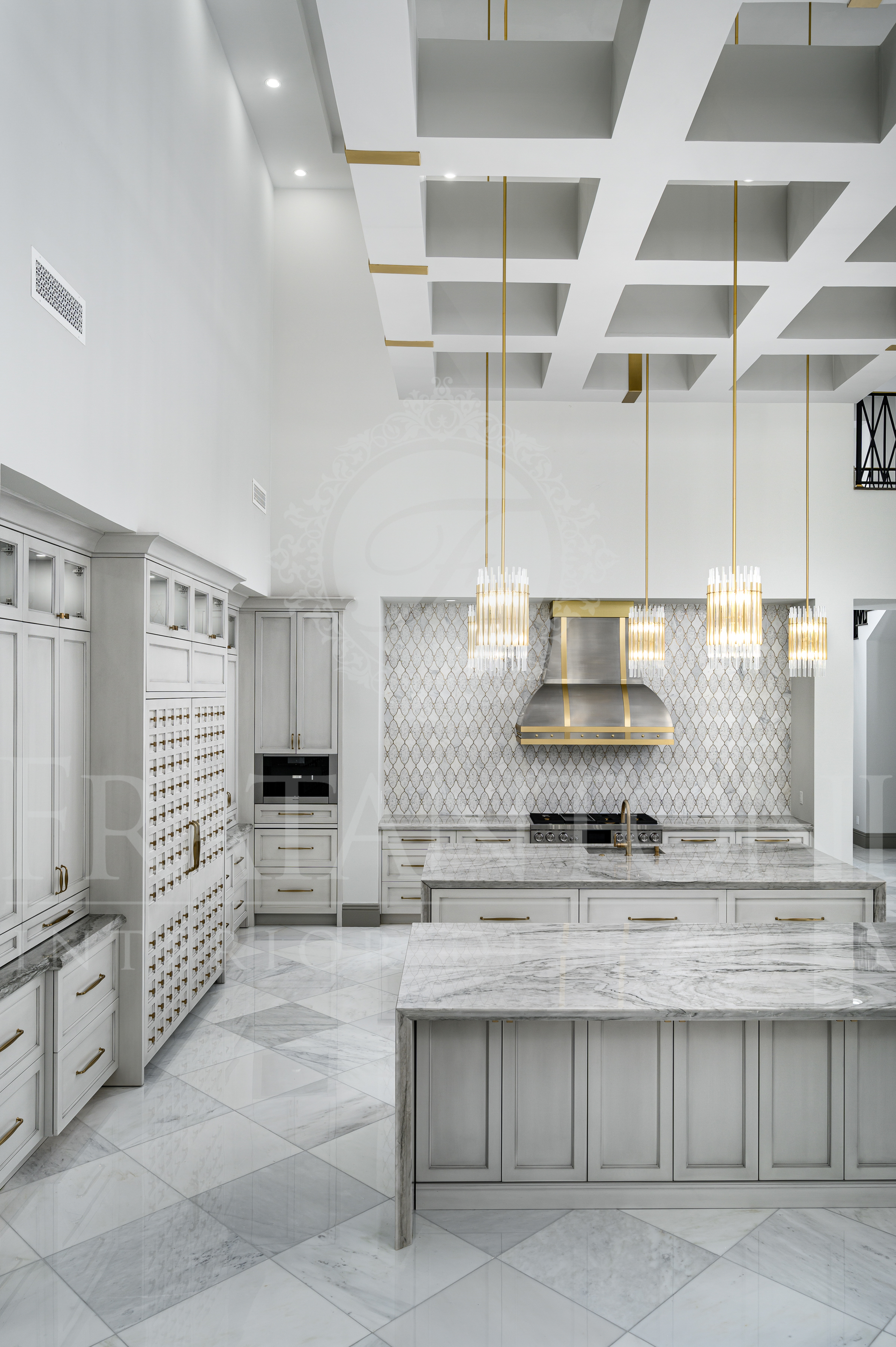 Elegant white kitchen with marble islands, patterned backsplash, pendant lights, and panel fridge. Designed by Fratantoni Interior Designers.