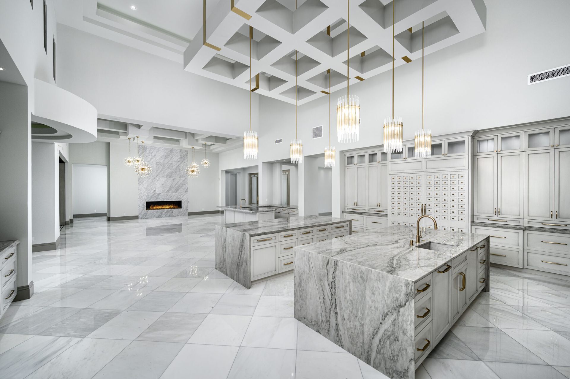 A large white kitchen with a large island in the middle.